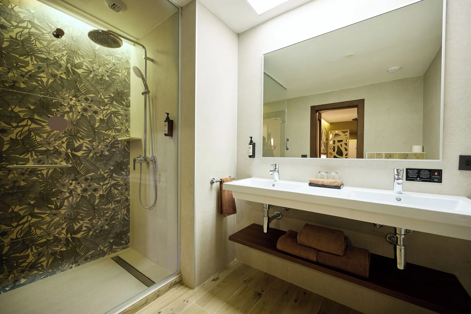 Guest bathroom with double sink vanity and glass shower at Hotel Riu Guanacaste.