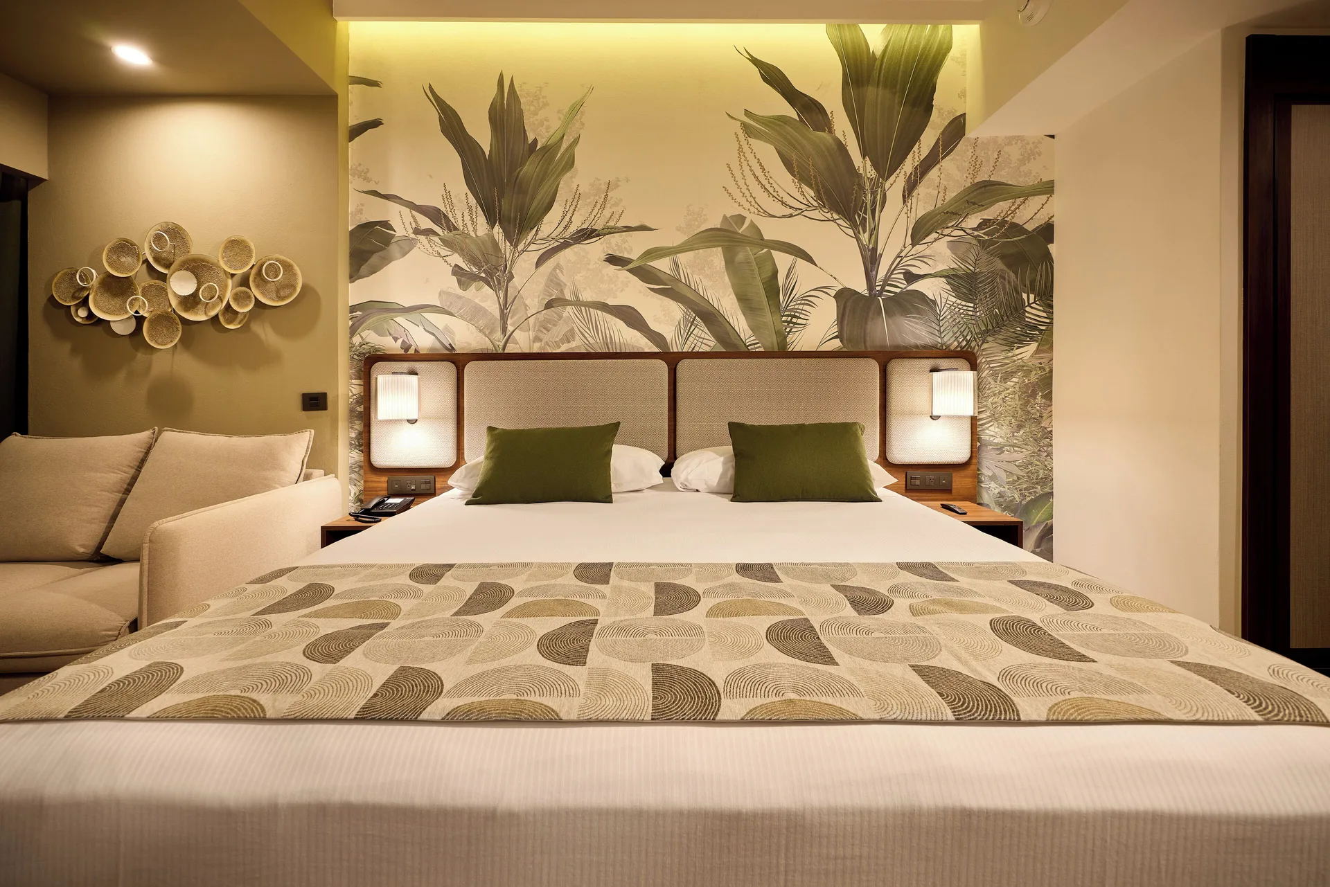 King bed with tropical mural and sofa beside it at Hotel Riu Guanacaste.