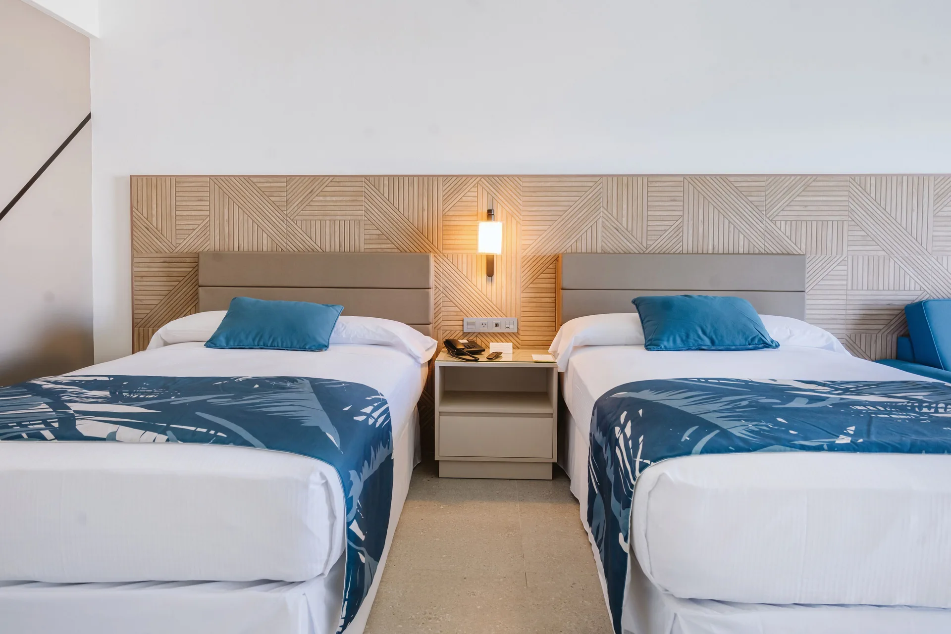 Partial Ocean View room with two beds and blue bed runners at Hotel Riu Latino.