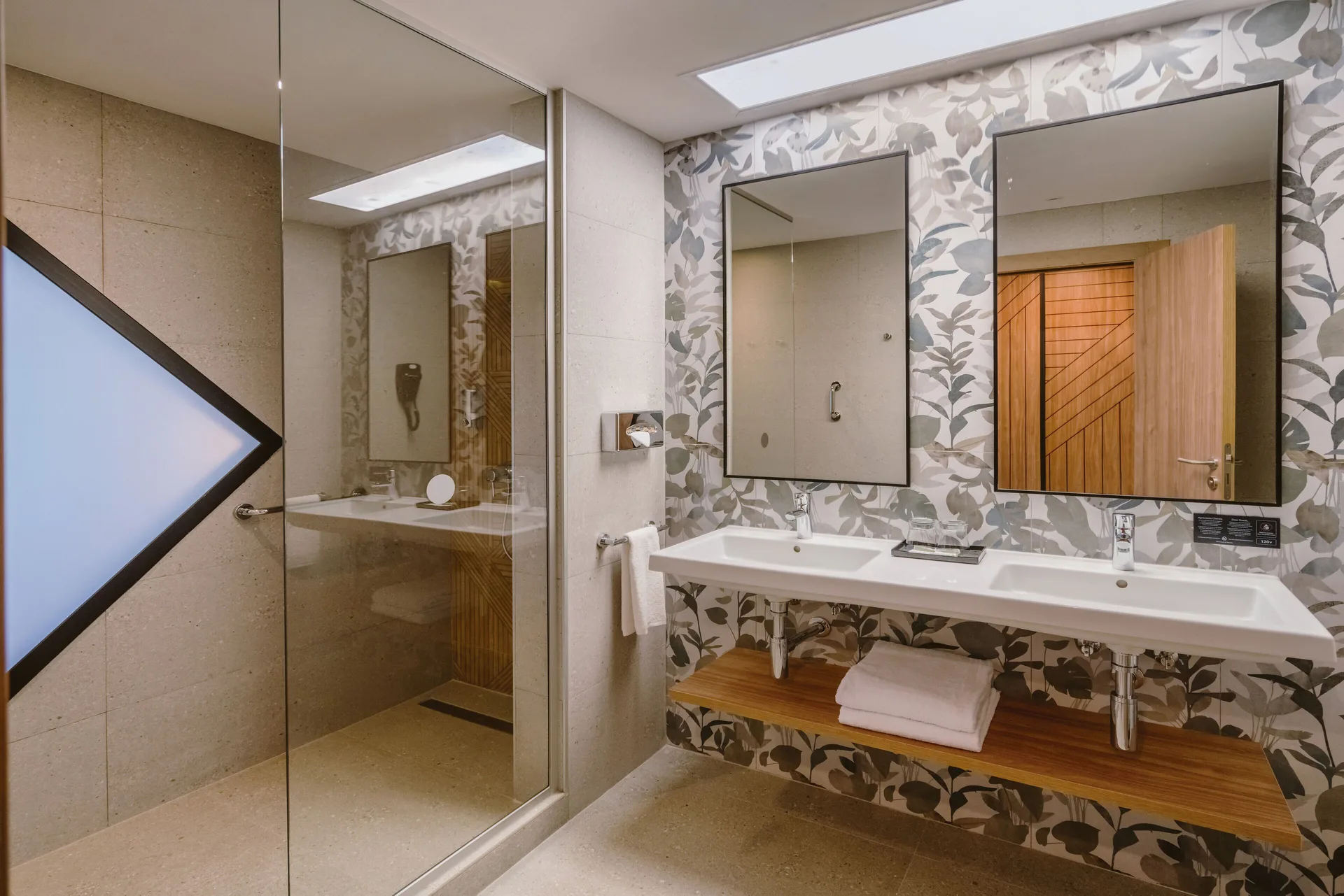 Bathroom with double vanity and glass shower in a Standard Room at Hotel Riu Latino.