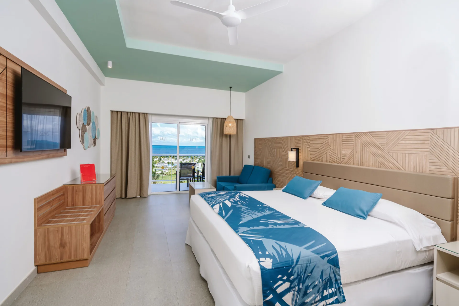 Ocean View Standard Room with king bed, sofa, and balcony at Hotel Riu Latino.