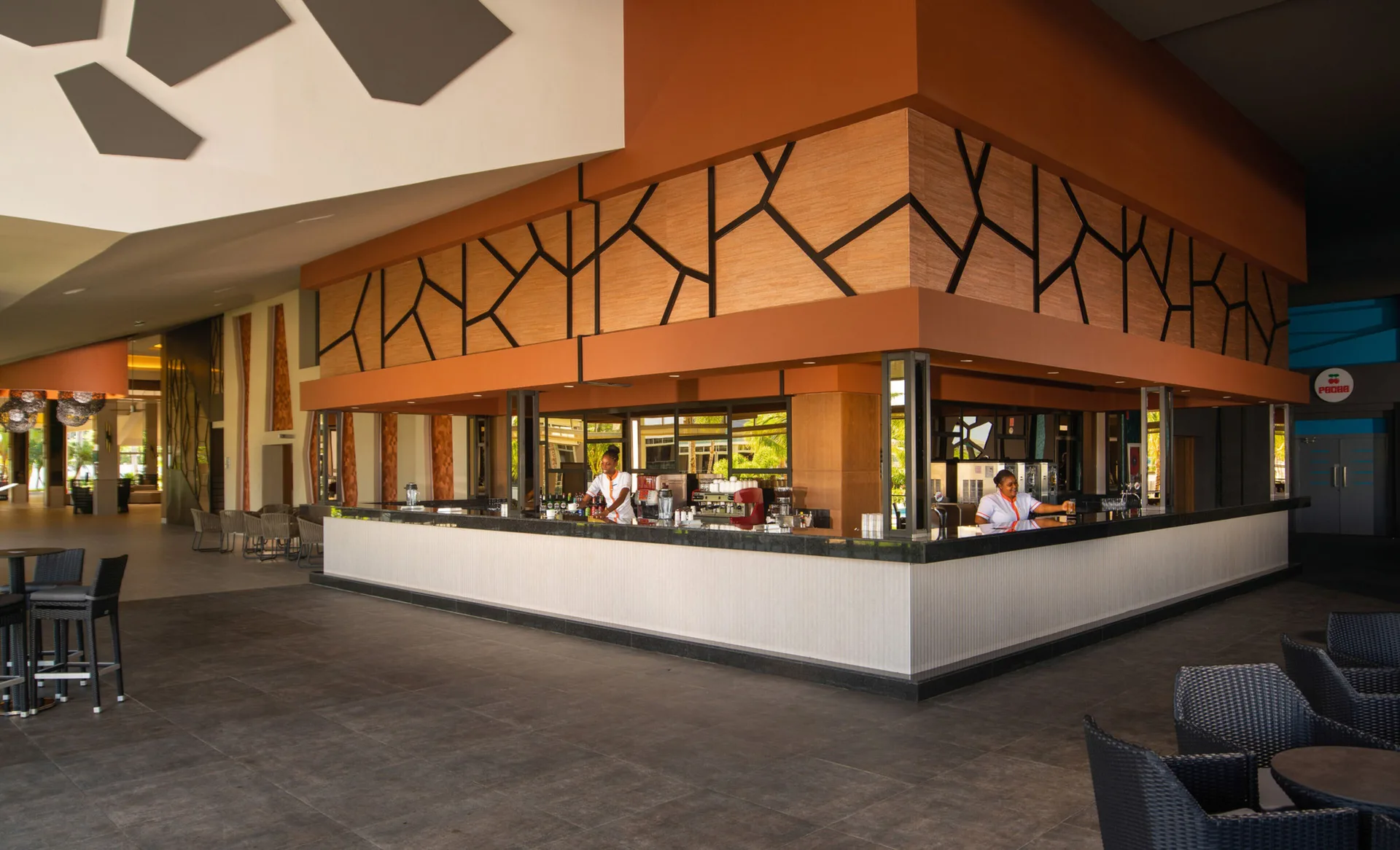 Open-air bar at Hotel Riu Montego Bay with a wraparound counter and shaded seating.