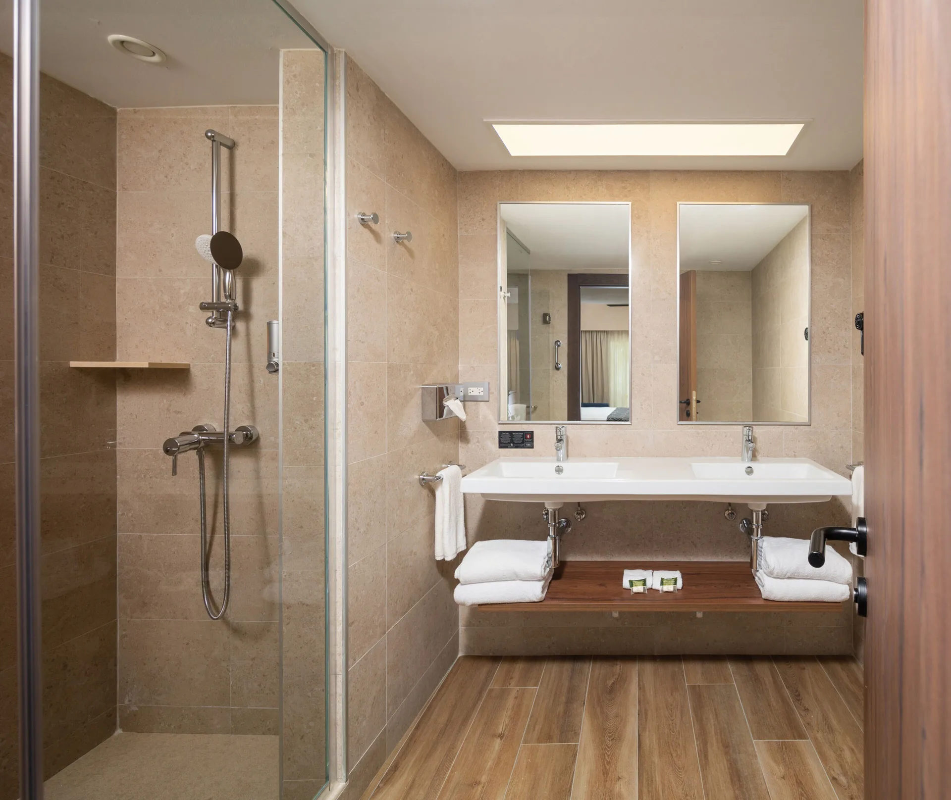 Garden View room bathroom with glass shower and double sinks at Hotel Riu Montego Bay.