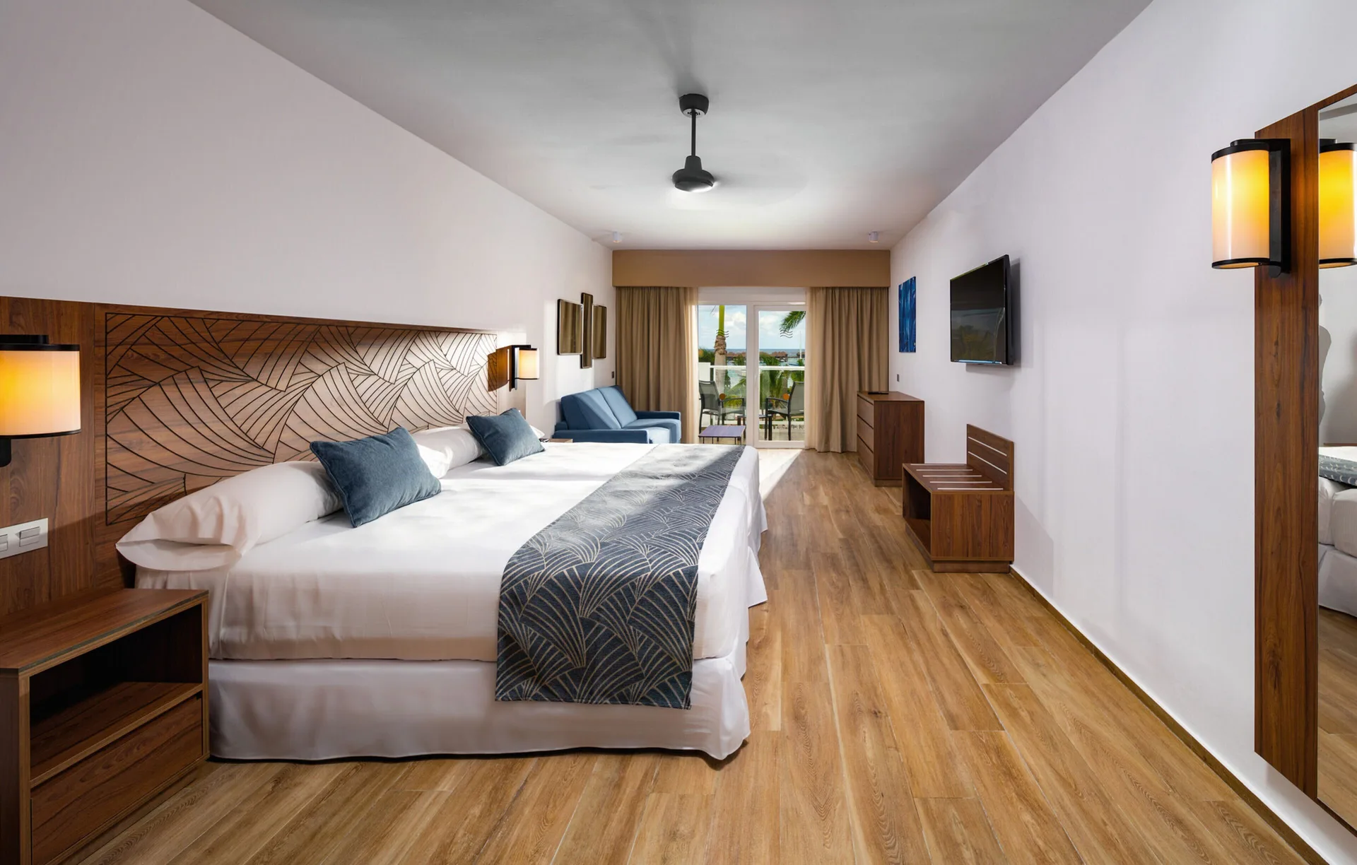 Garden View room with king bed, balcony doors, and lounge chairs at Hotel Riu Montego Bay.