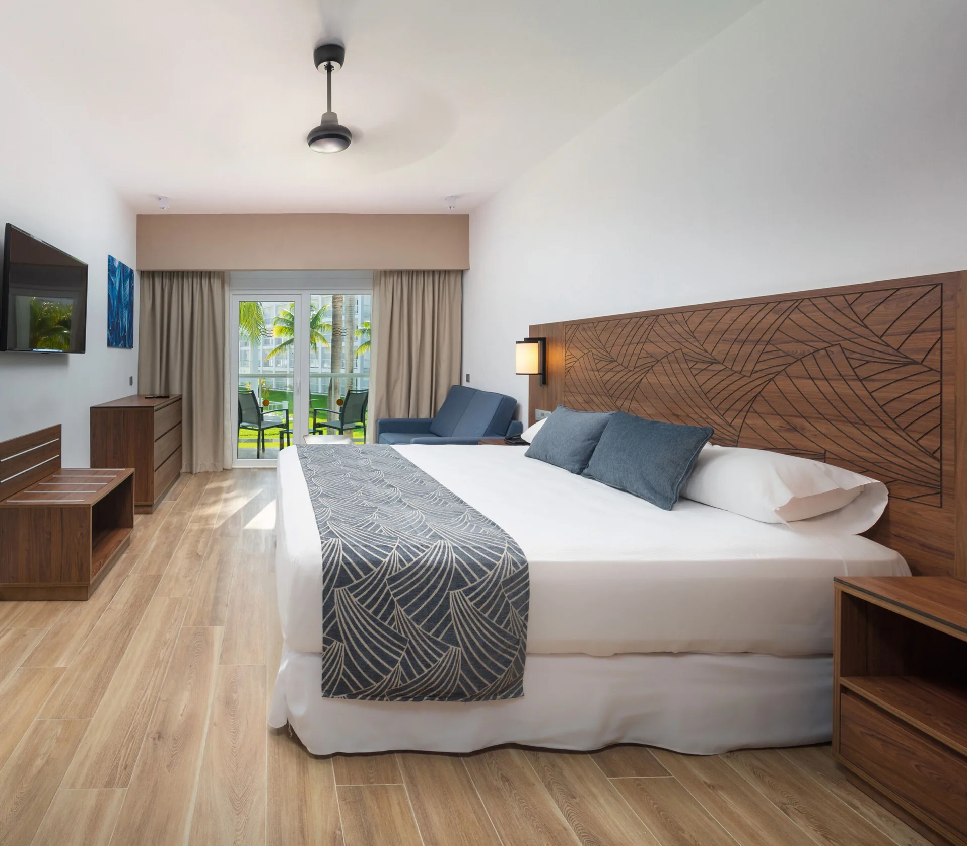 Garden View room with king bed and balcony seating at Hotel Riu Montego Bay.