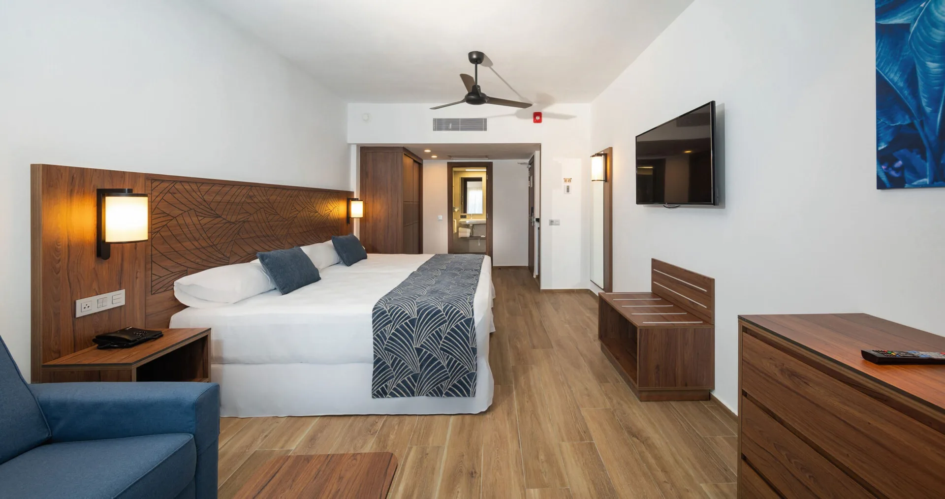 Garden View room with king bed, sofa, TV, and open bathroom area at Hotel Riu Montego Bay.
