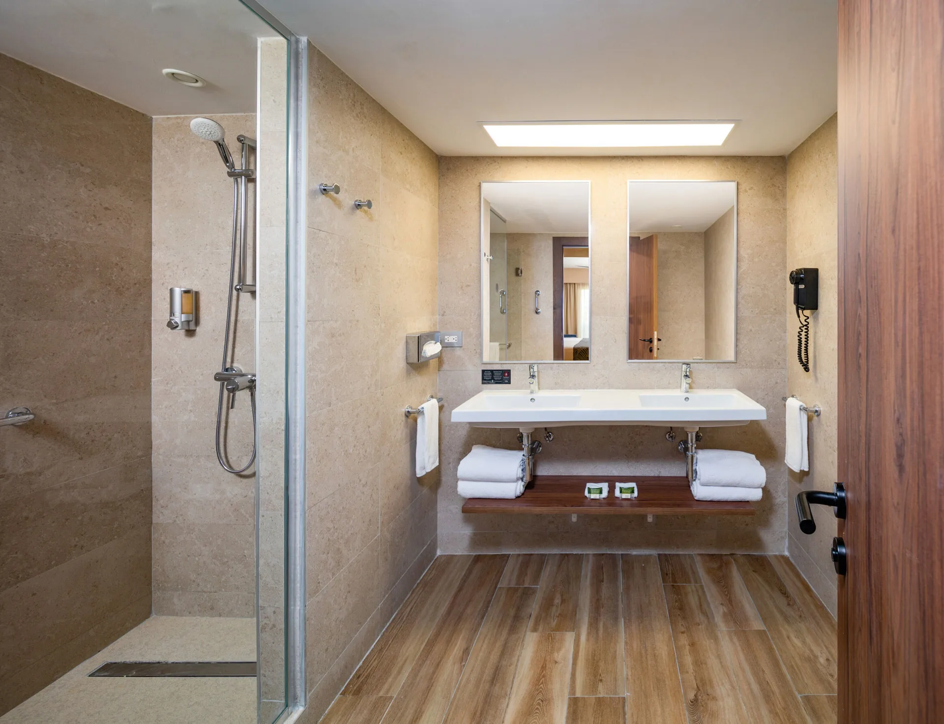 Guest bathroom with double sink vanity and glass shower at Hotel Riu Montego Bay.