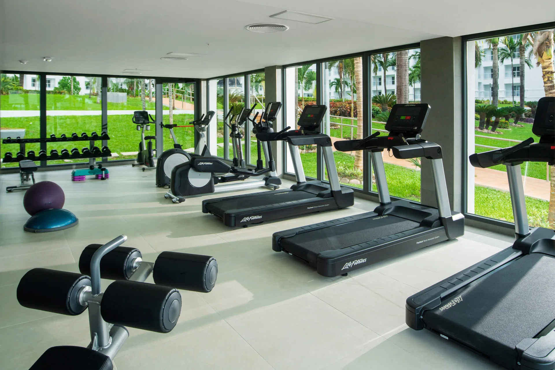 Fitness room with treadmills, bikes, and weights at Hotel Riu Ocho Rios.