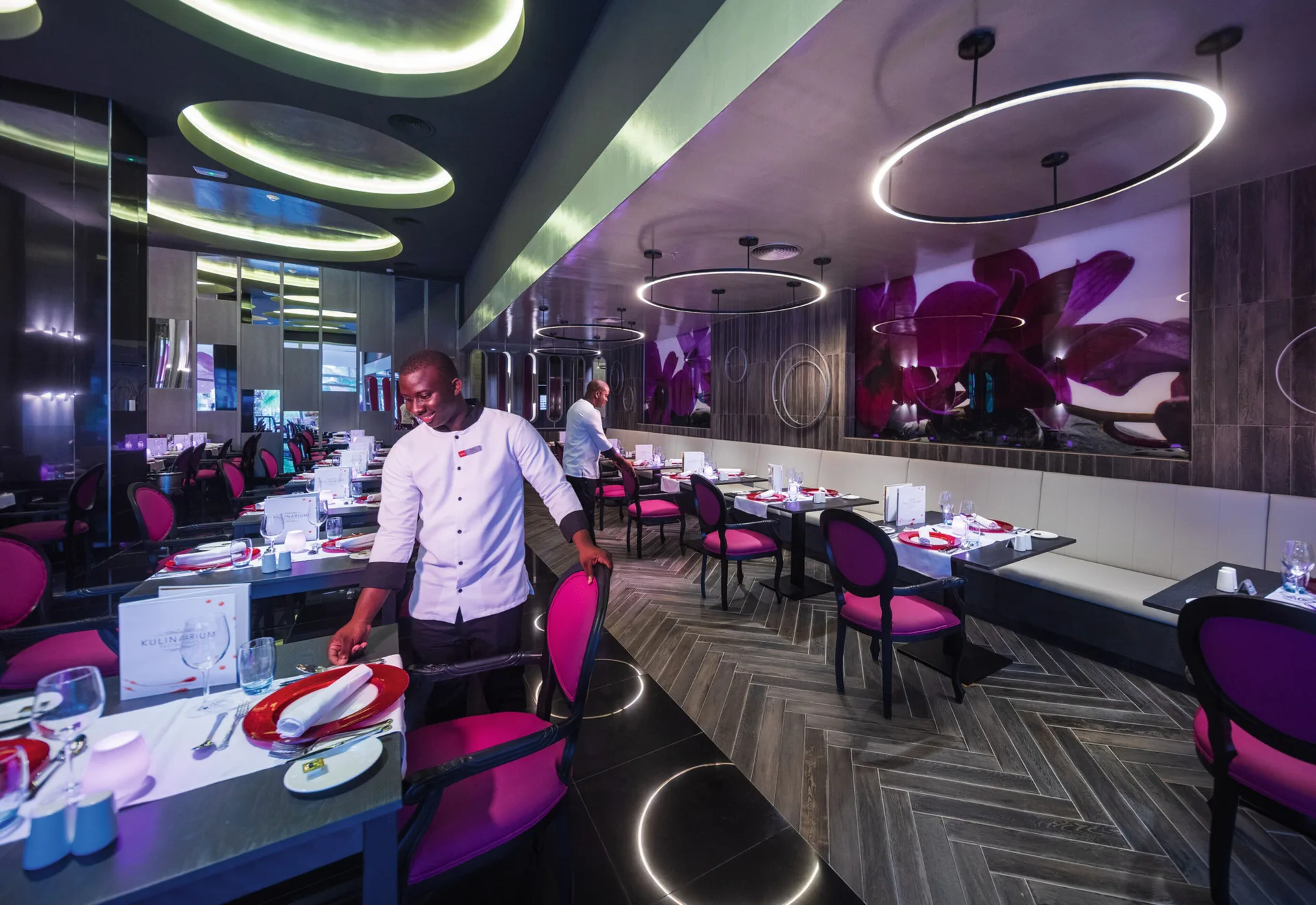 Kulinarium dining room with pink chairs and circular lights at Hotel Riu Ocho Rios.