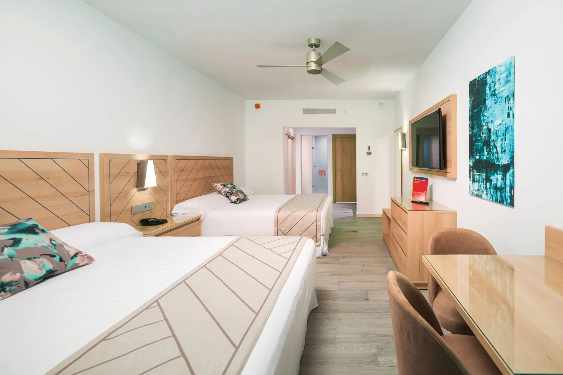 Family Room with two beds, desk, TV, and dresser at Hotel Riu Ocho Rios.
