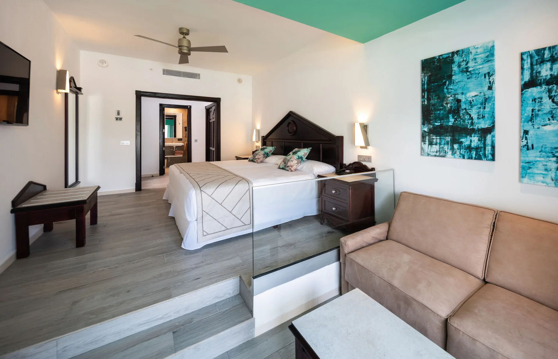 Junior Suite Garden View with bed, sofa, and split-level seating at Hotel Riu Ocho Rios.