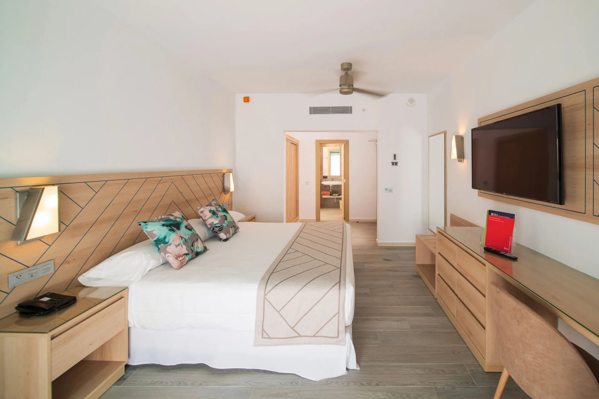 Oceanfront guest room with king bed and wall-mounted TV at Hotel Riu Ocho Rios.