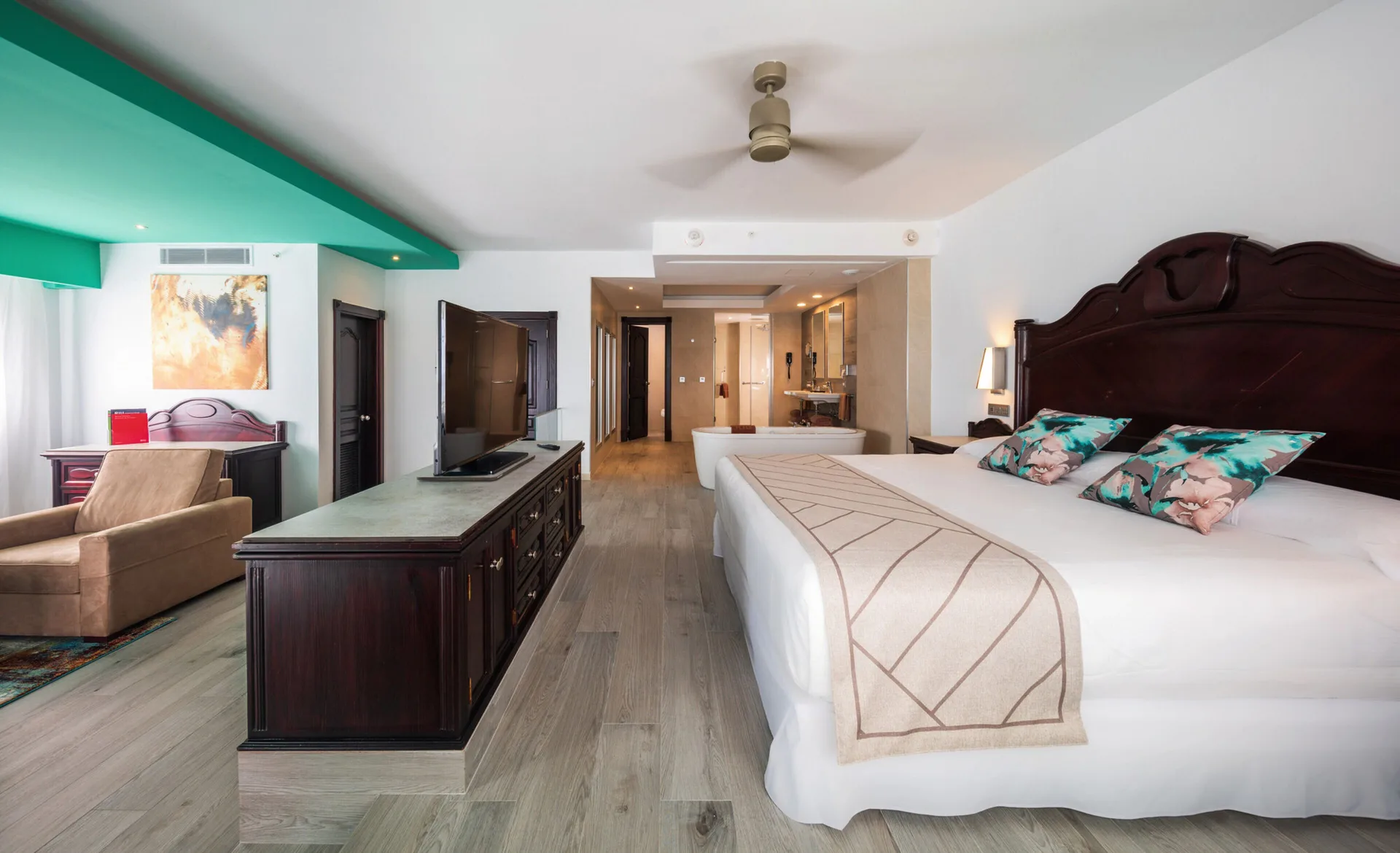 Ocean View Suite with king bed, sofa area and open bathroom at Hotel Riu Ocho Rios.