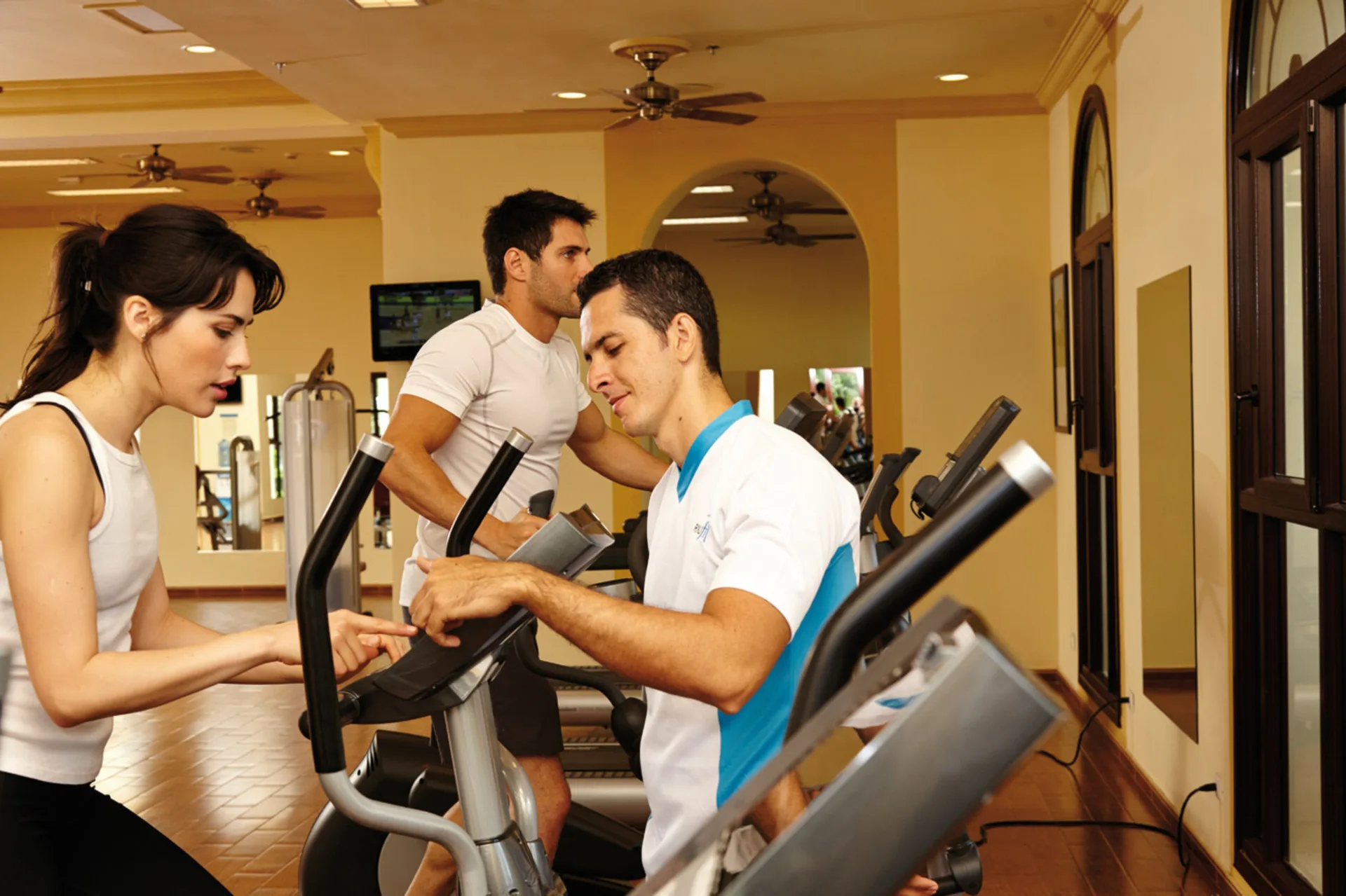 Guests using cardio machines in the fitness room at Hotel Riu Palace Costa Rica.