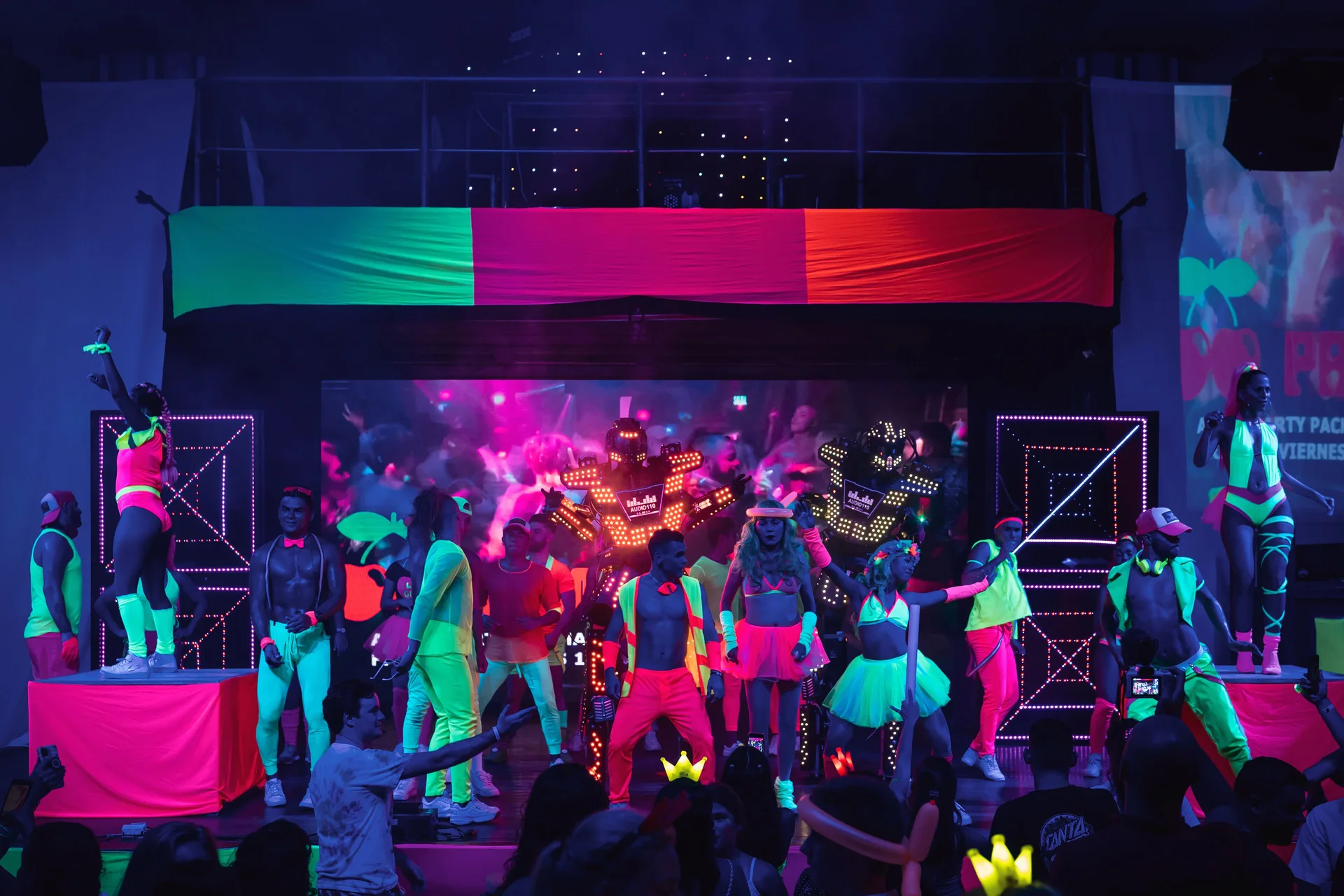 A neon stage show with dancers and LED robots fills the venue at Hotel Riu Palace Costa Rica.