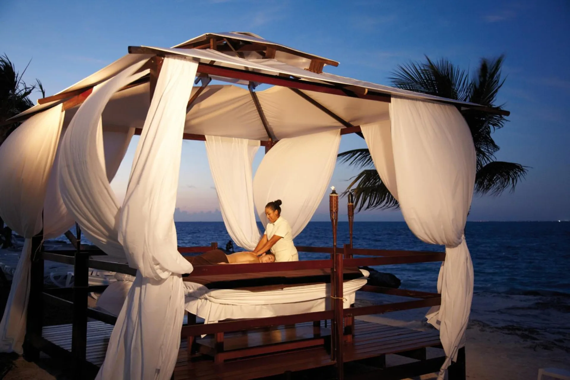 Beachfront massage under a white-draped cabana at Hotel Riu Palace Peninsula.