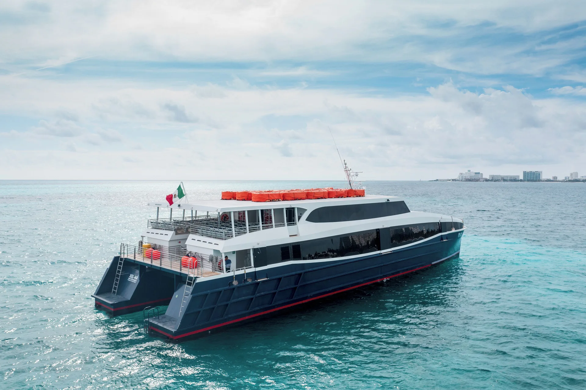 Passenger ferry on turquoise ocean water near Hotel Xcaret Arte.