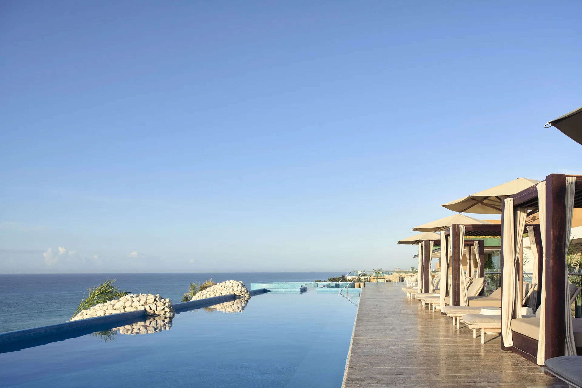 Rooftop infinity pool with ocean views and cabanas at Hotel Xcaret Arte.