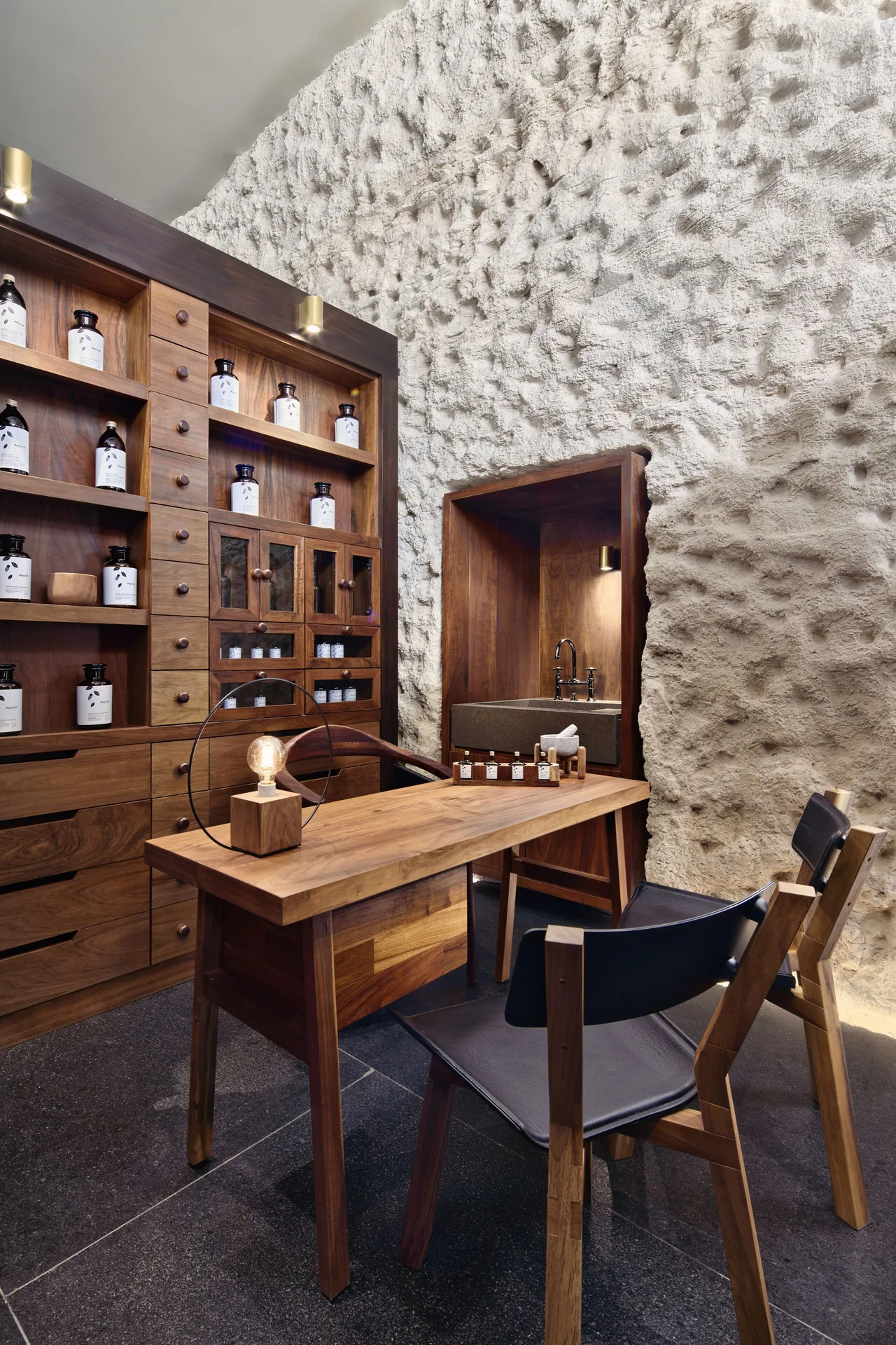 Spa consultation room with wooden shelves and bottled amenities at Hotel Xcaret Arte.