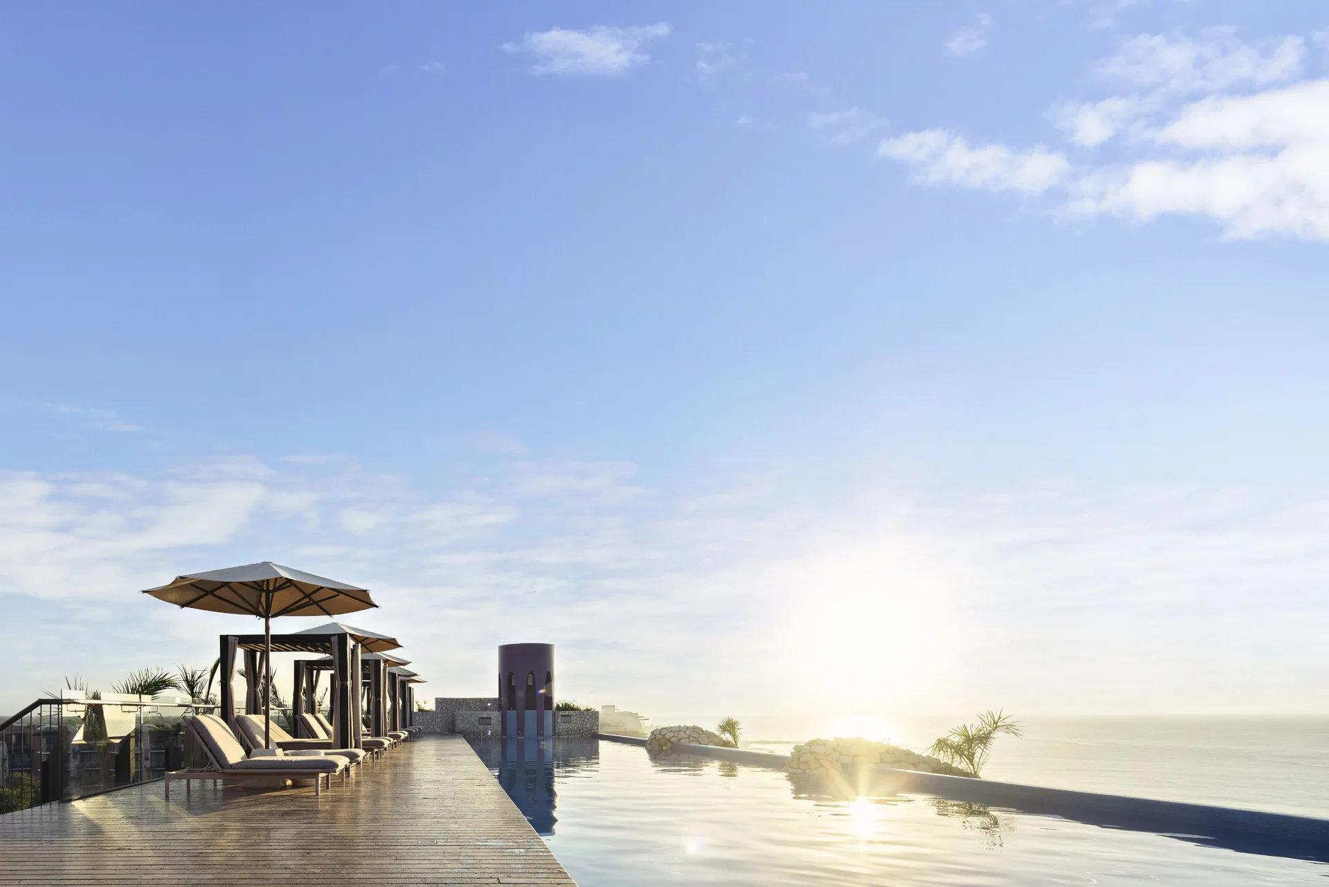 Sunrise over a rooftop infinity pool and ocean at Hotel Xcaret Arte.