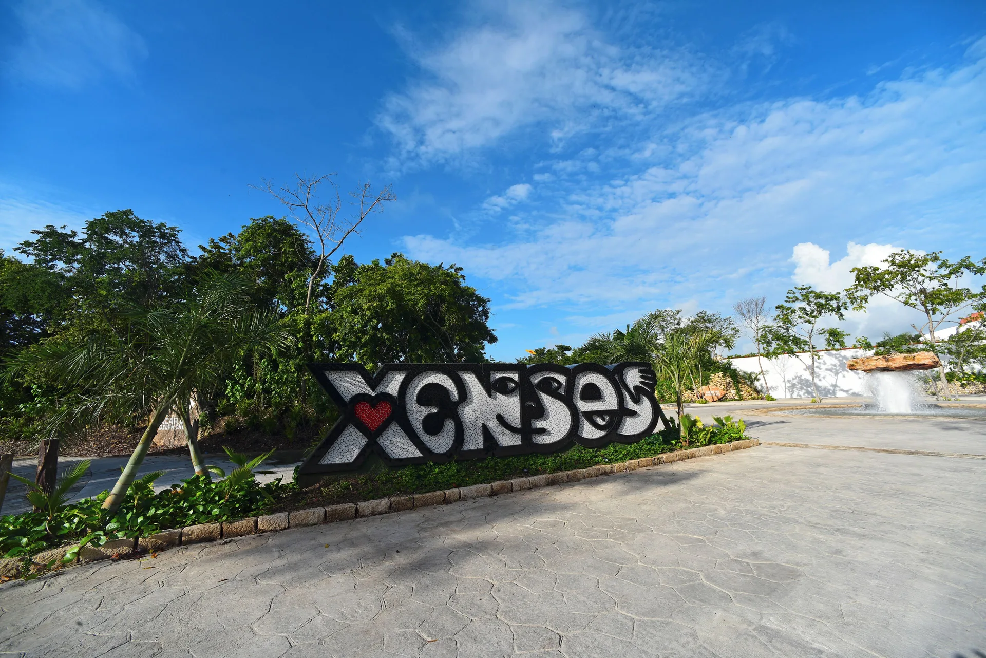 Xenses sign by a landscaped roadway near Hotel Xcaret Arte.