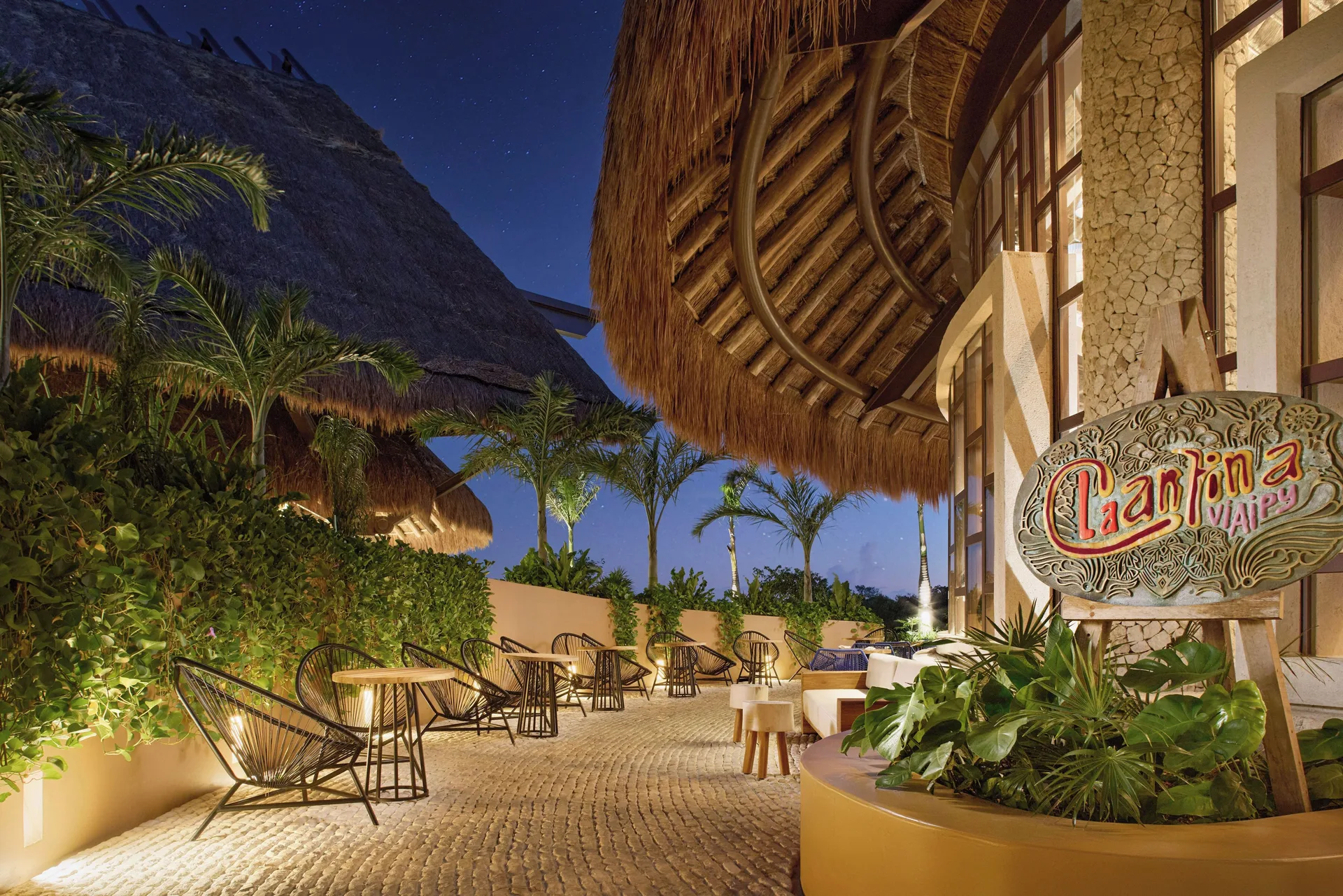 Cantina VI.AI.PY terrace with palapa roofs at Hotel Xcaret Arte.