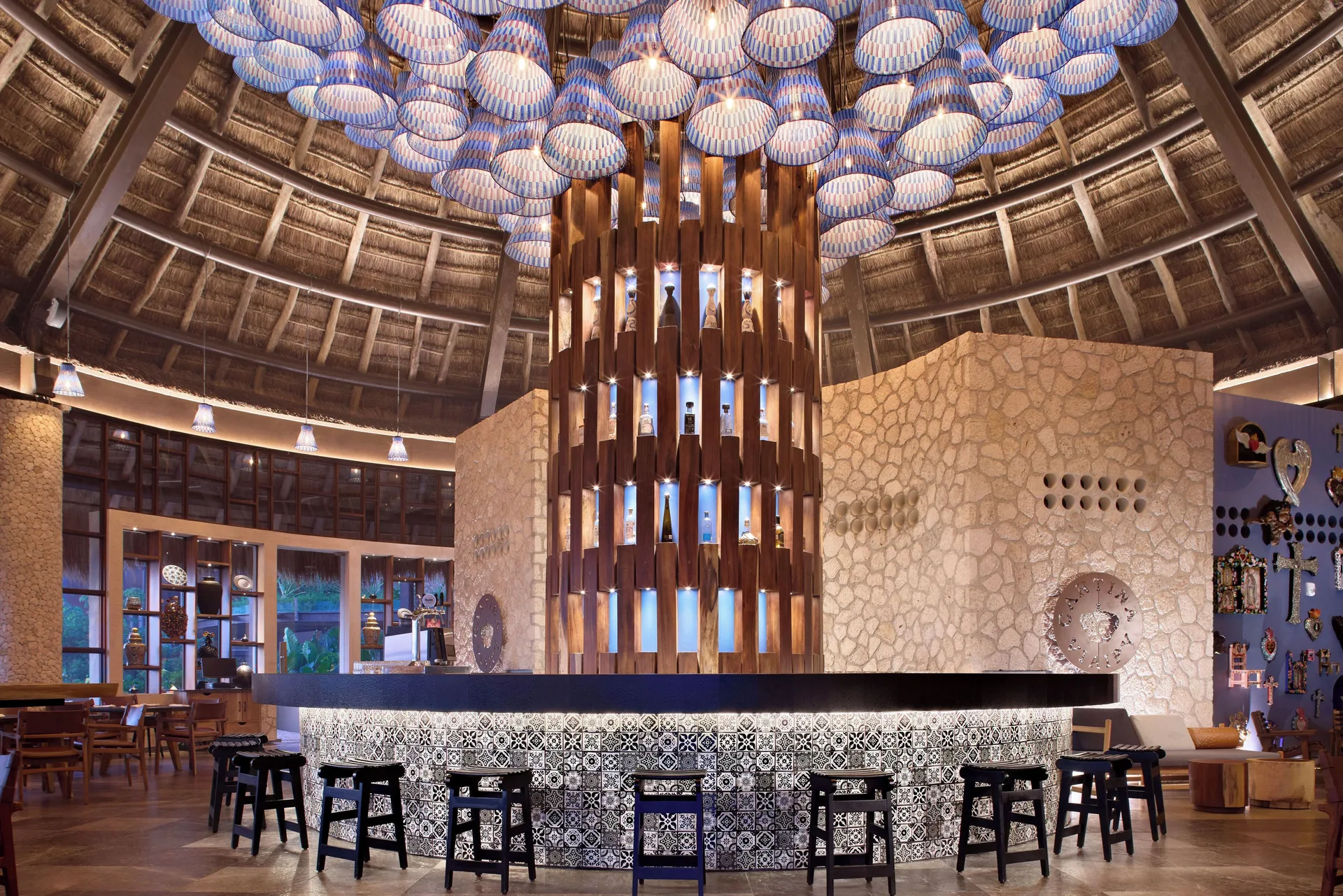 Circular tiled bar beneath blue pendant lights at Hotel Xcaret Arte.