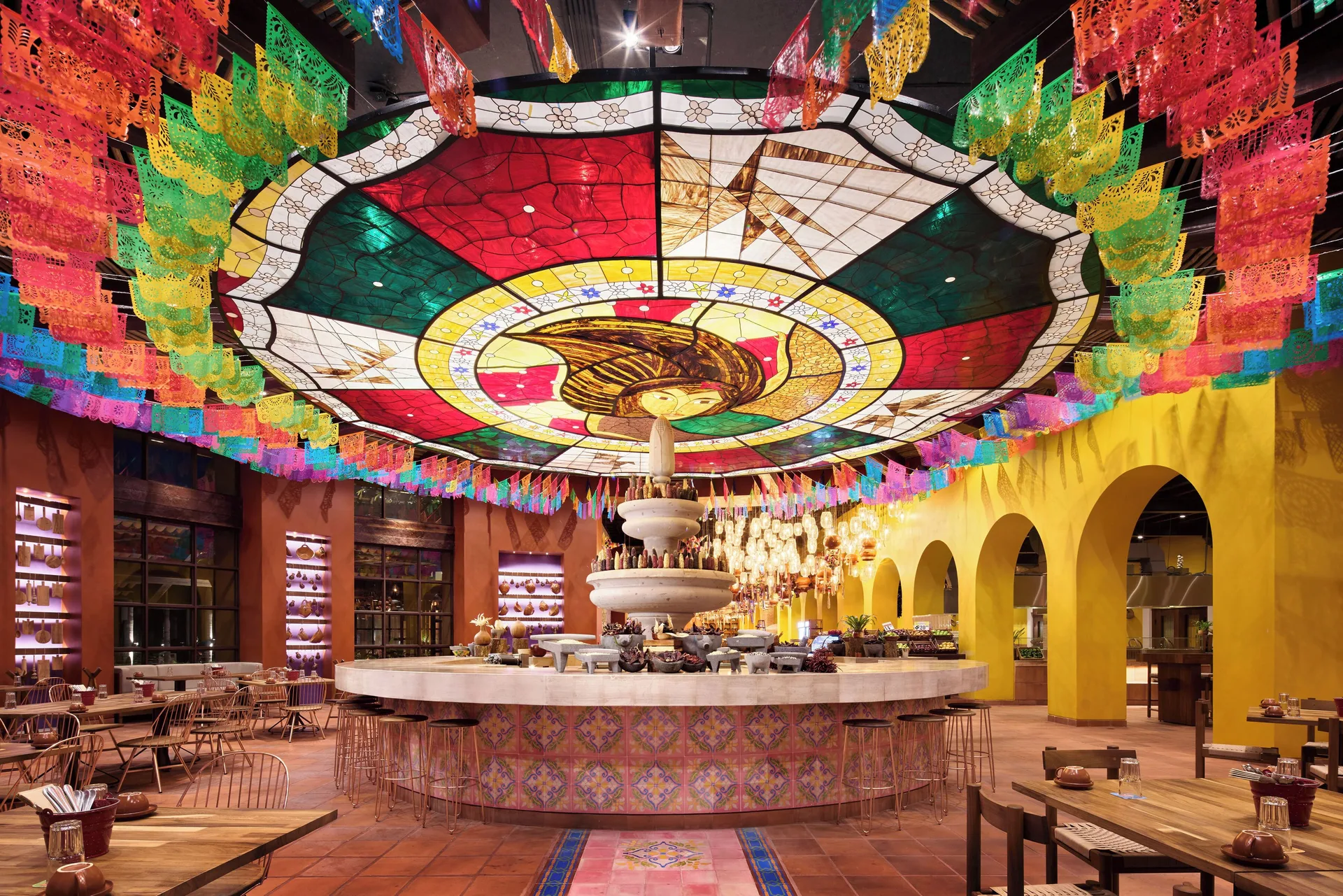 Colorful buffet restaurant with papel picado at Hotel Xcaret Arte.