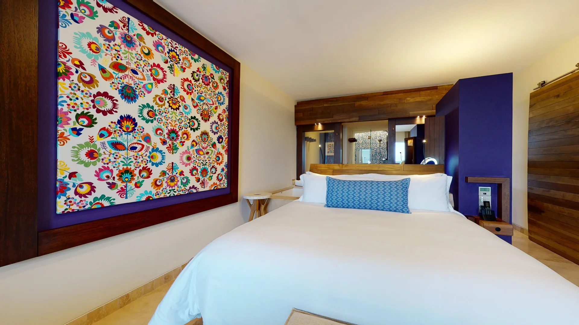 Junior Suite Ocean View bedroom with king bed and colorful wall art at Hotel Xcaret Arte.