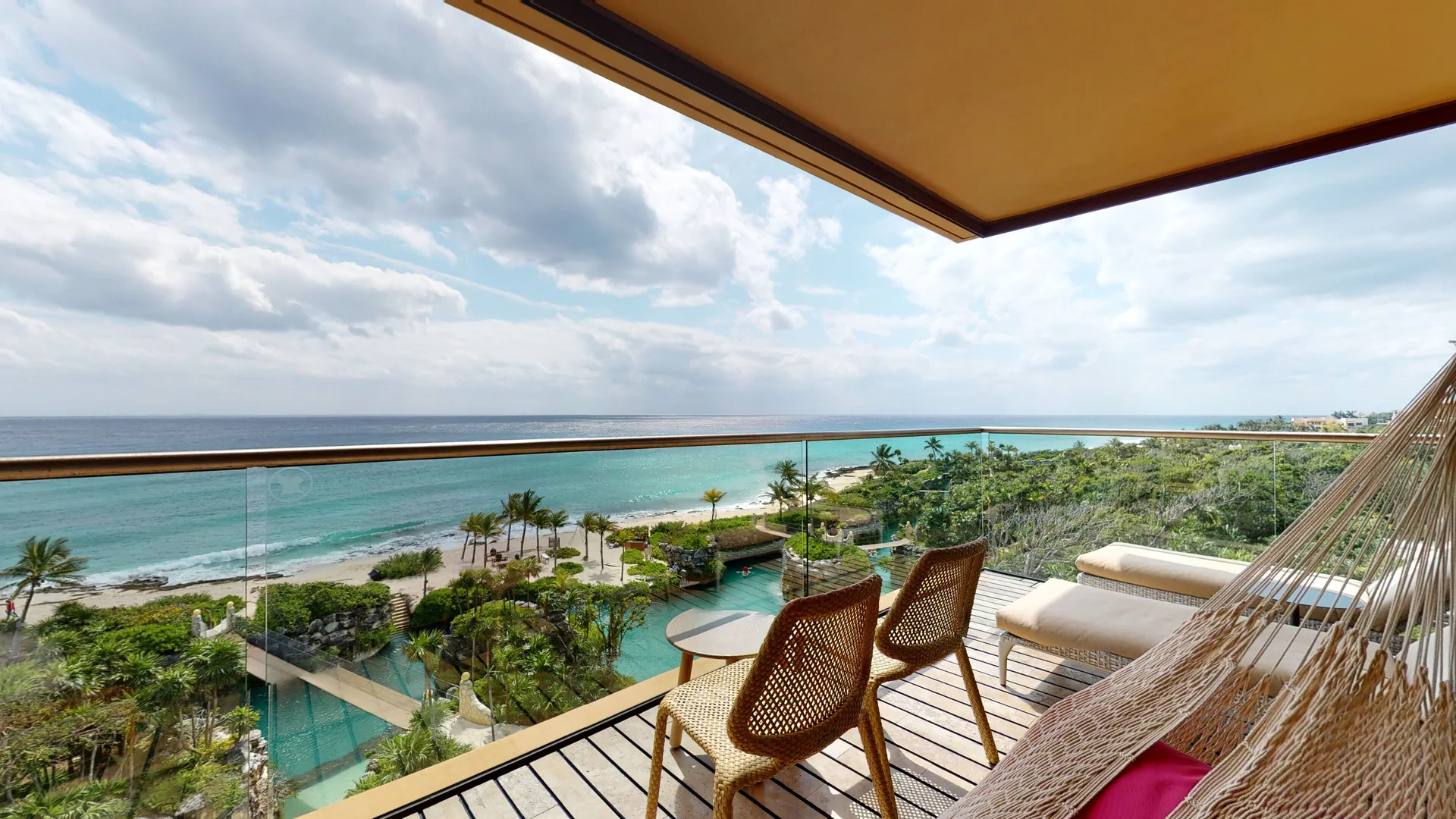 Oceanfront Junior Suite balcony with hammock and Caribbean Sea view at Hotel Xcaret Arte.