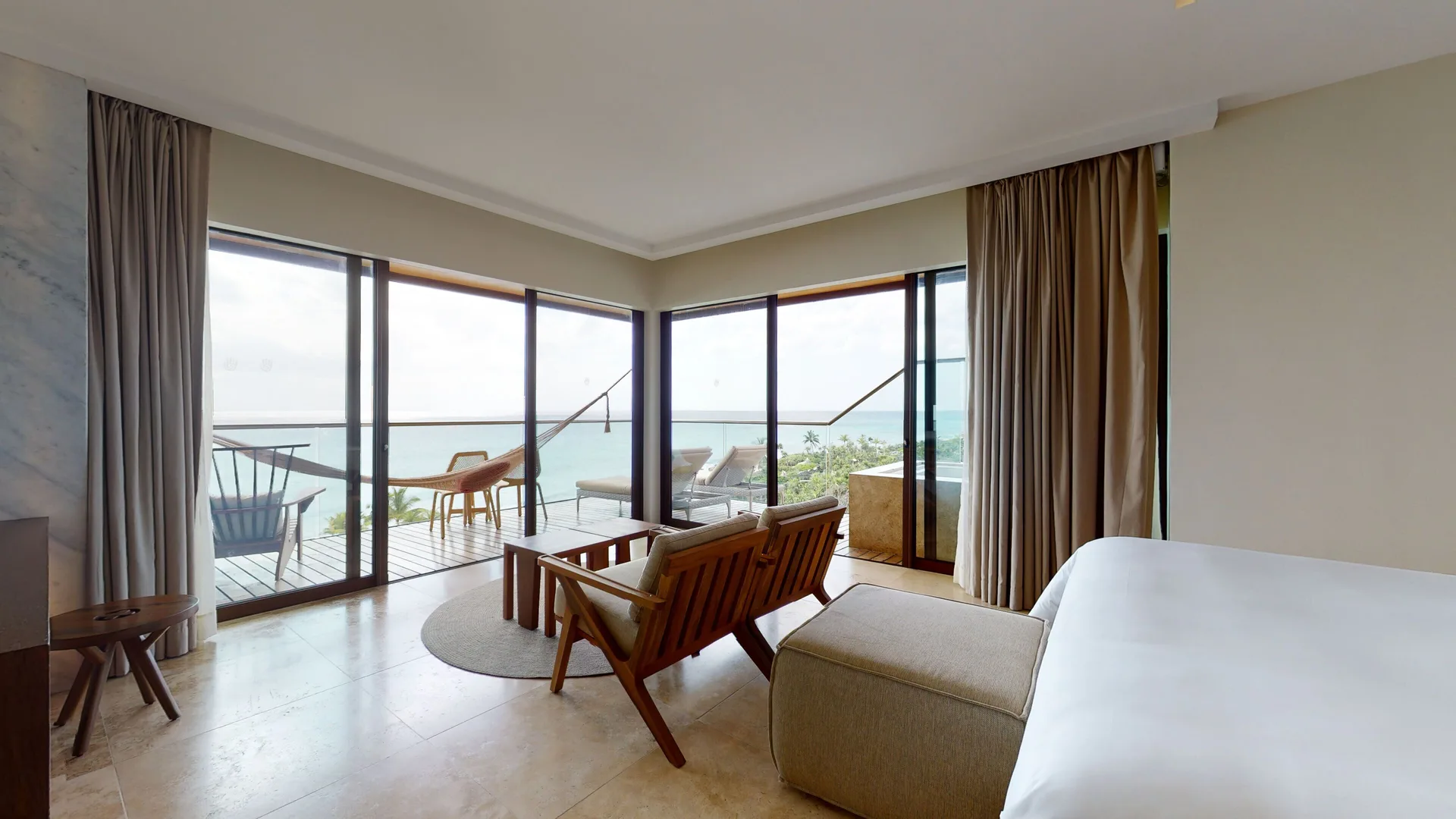 Oceanfront Junior Suite with bed, seating area and balcony views at Hotel Xcaret Arte.