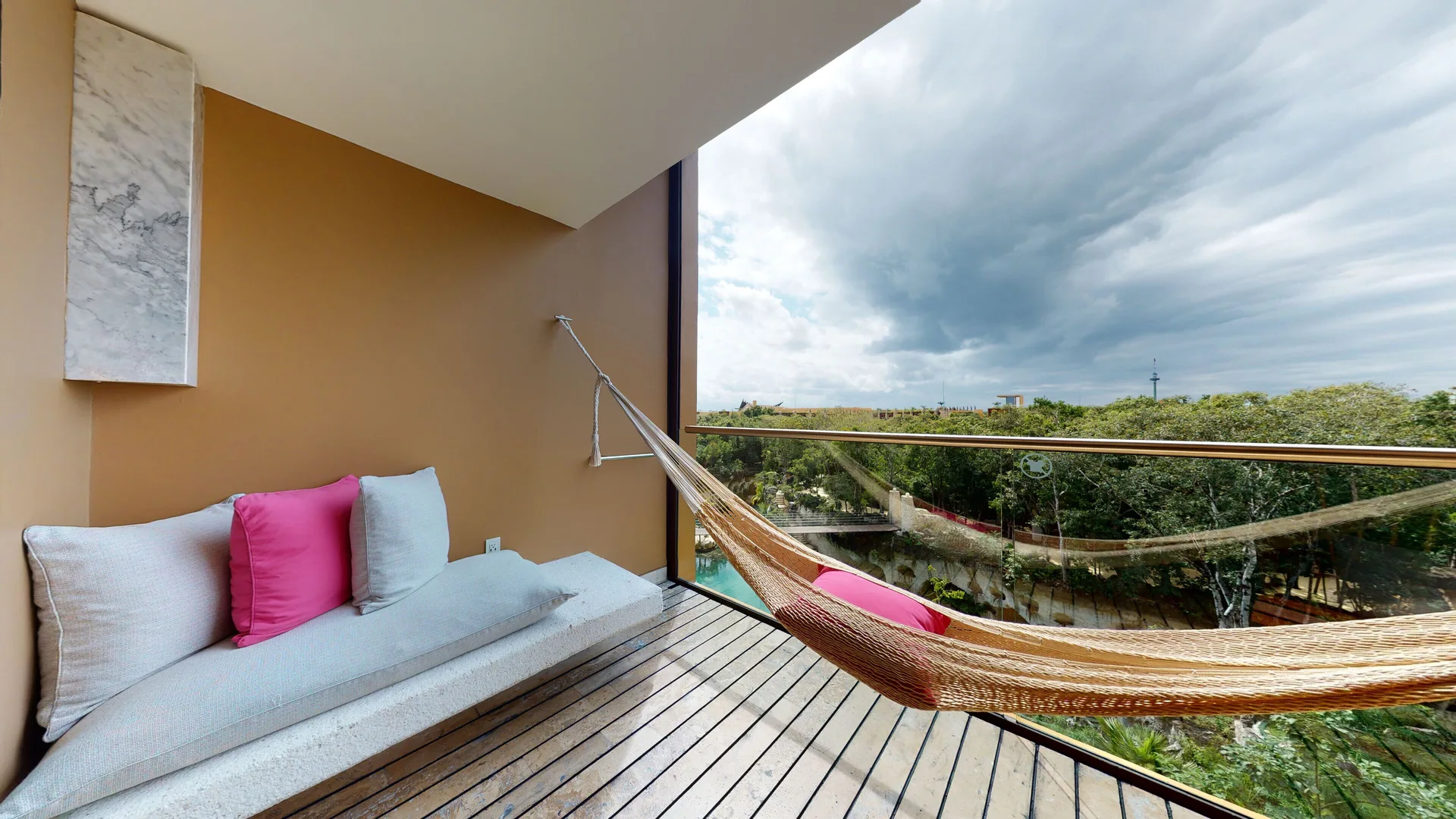 Junior Suite River Spa balcony at Hotel Xcaret Arte with hammock, daybed, and treetop river view