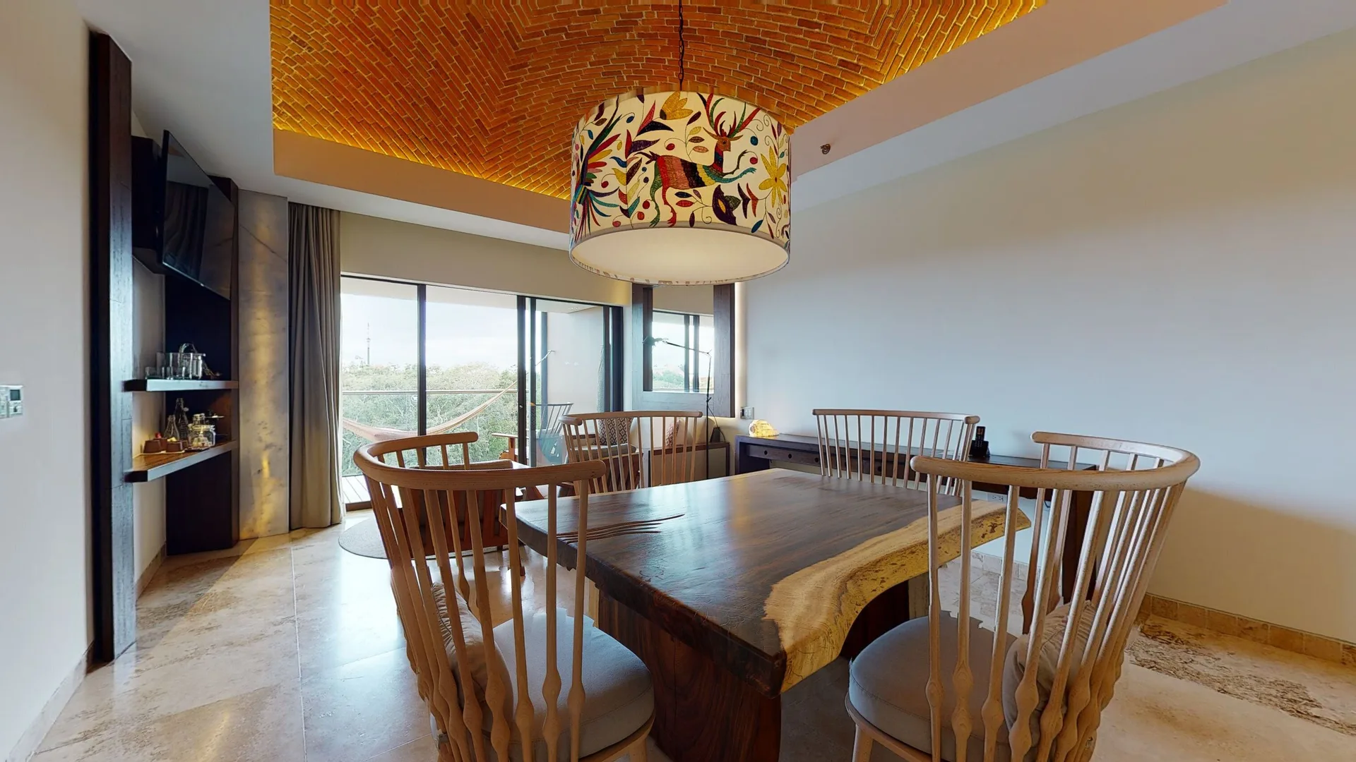 Junior Suite River Spa dining table at Hotel Xcaret Arte beneath a patterned pendant and brick ceiling