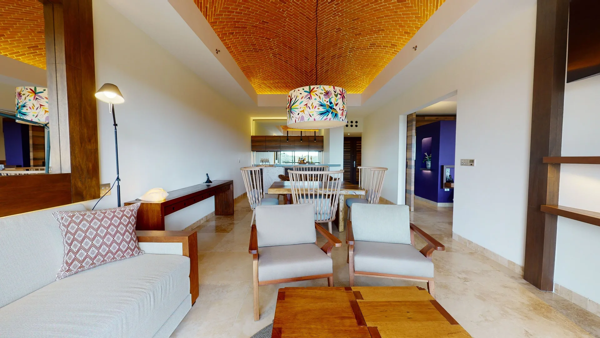 Junior Suite River Spa living and dining area at Hotel Xcaret Arte with wood seating and brick ceiling