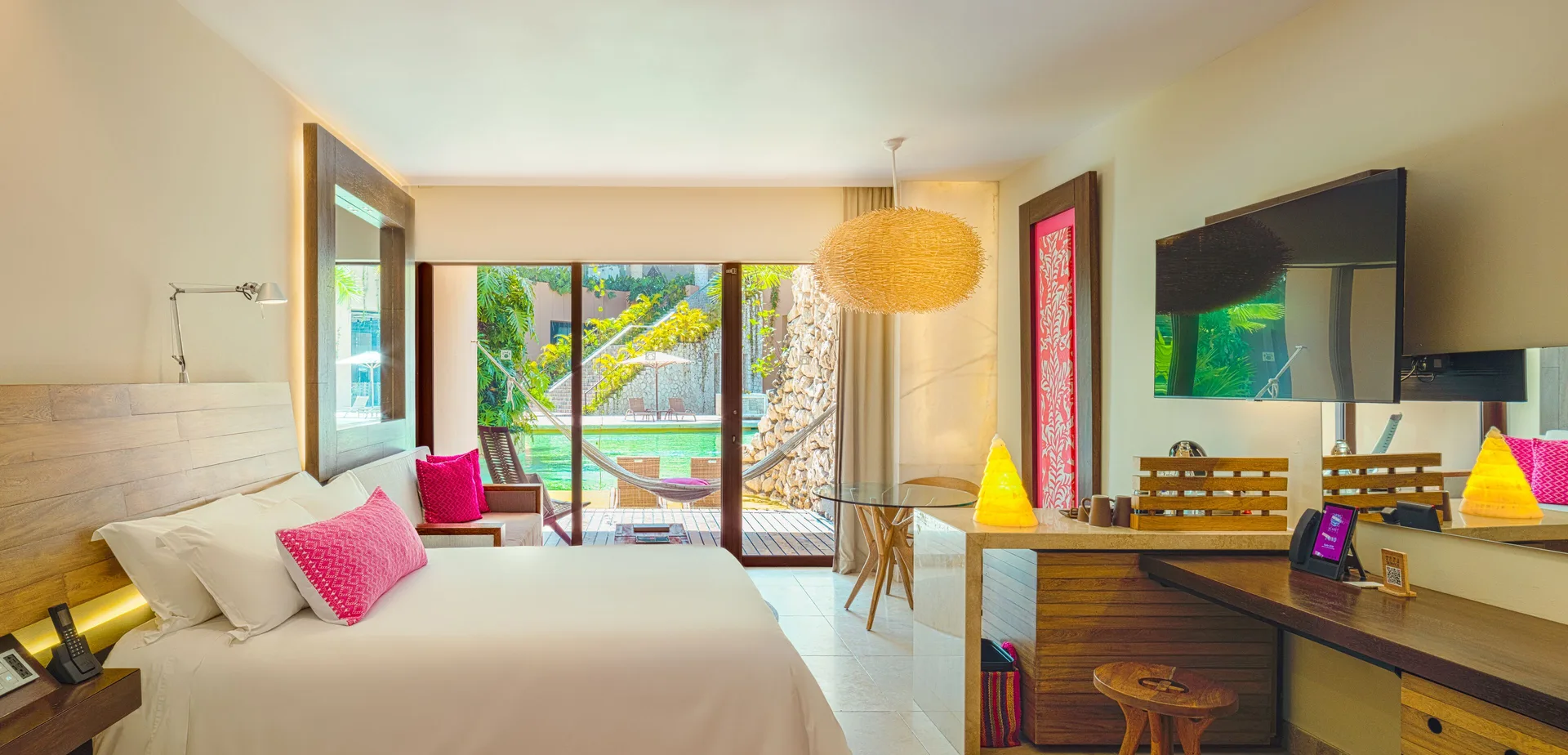 Garden Swim Up room with king bed, desk, and poolside terrace at Hotel Xcaret Arte.