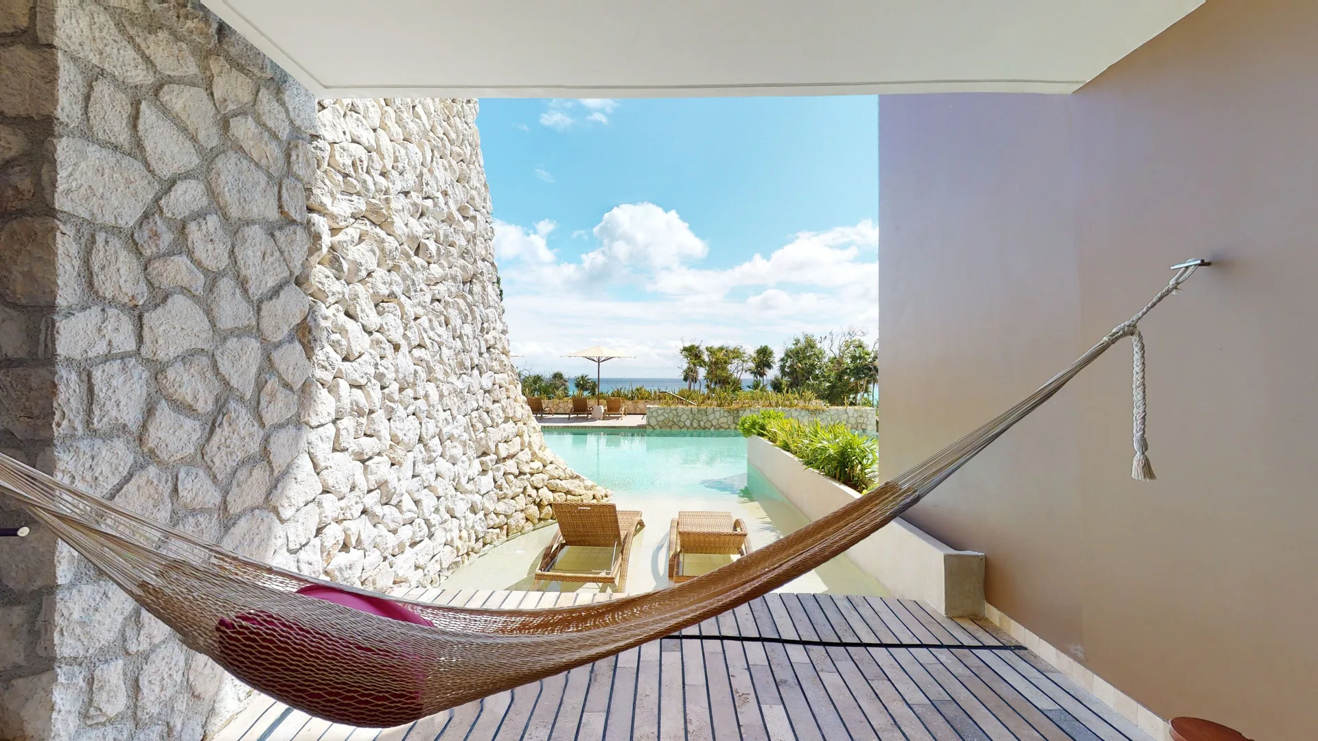 Private swim-up terrace with hammock and loungers at Hotel Xcaret Arte.