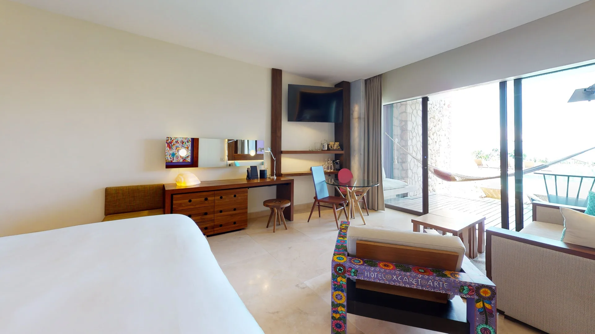 Oceanfront swim-up room with king bed, sitting area and terrace at Hotel Xcaret Arte.