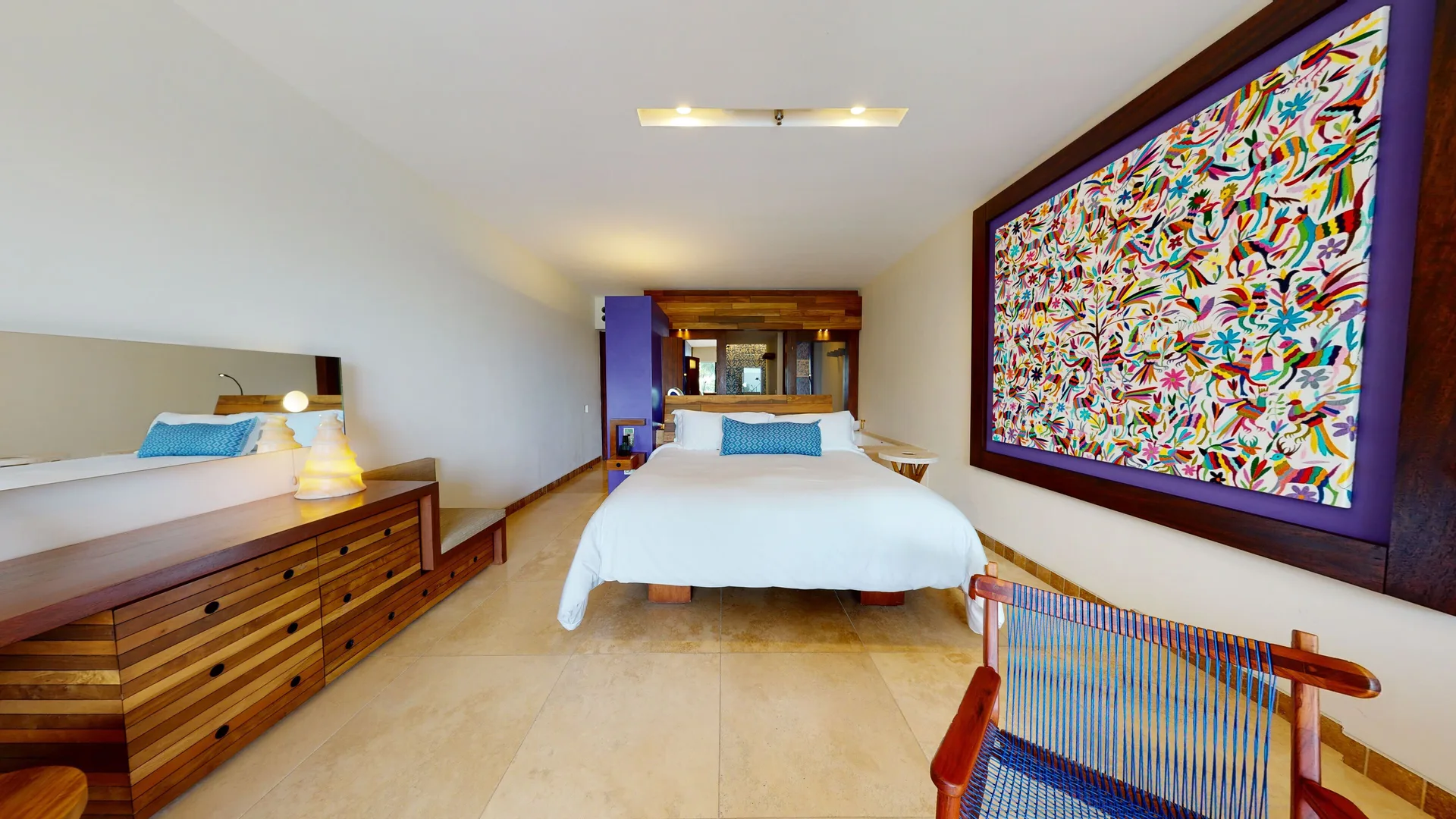 Oceanfront room with king bed and colorful wall art at Hotel Xcaret Arte.
