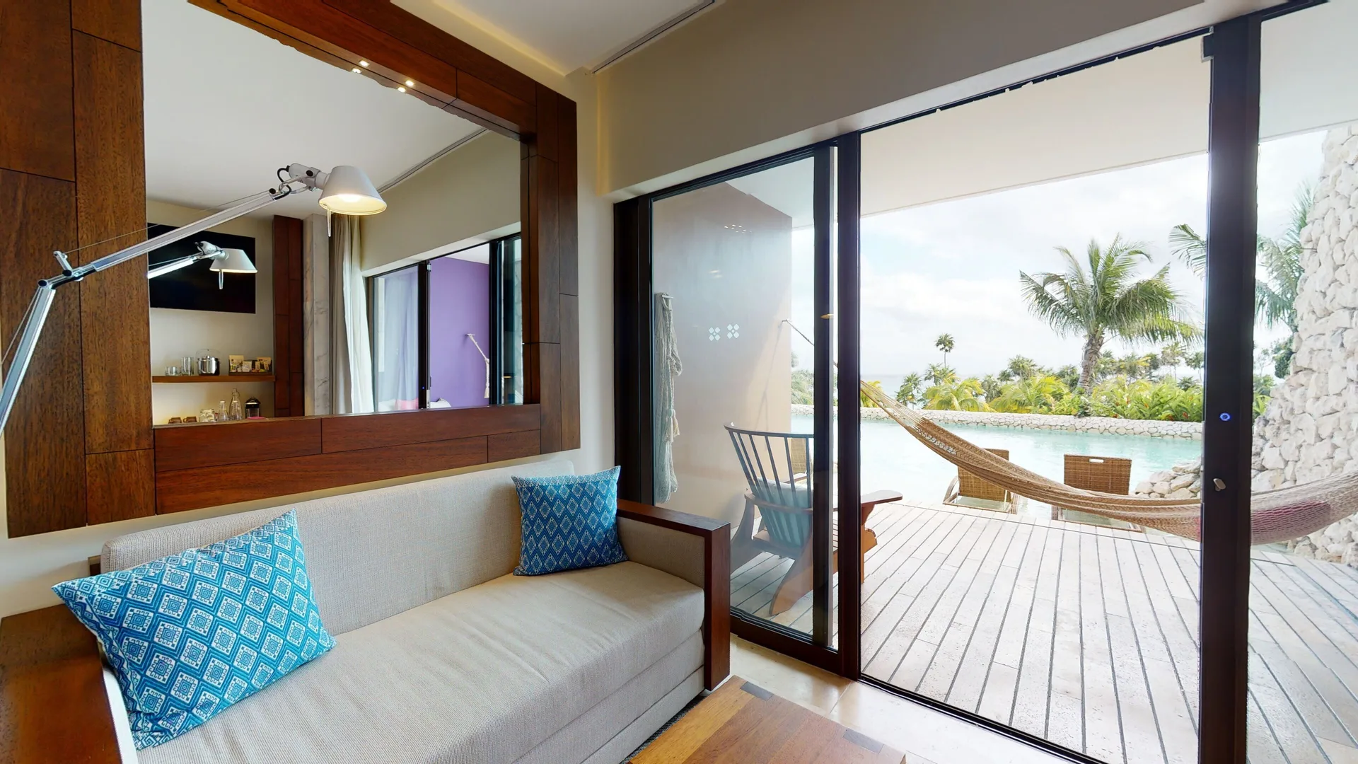 Oceanfront room sitting area and terrace with hammock at Hotel Xcaret Arte.