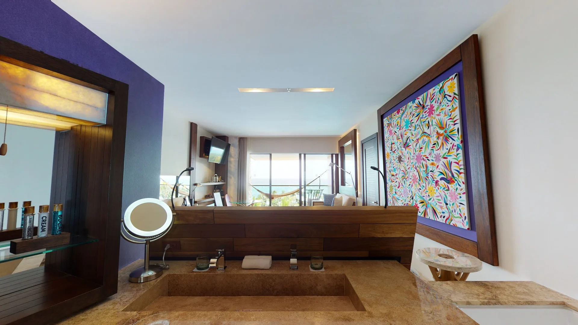 Oceanfront suite bathroom vanity and sea-facing room beyond at Hotel Xcaret Arte.