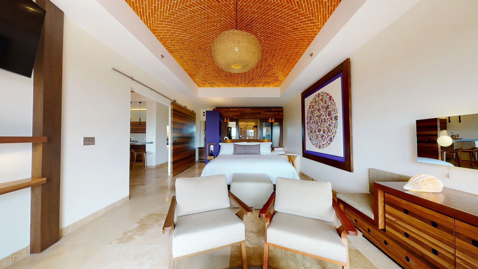 Oceanfront suite bedroom with king bed and lounge chairs at Hotel Xcaret Arte.