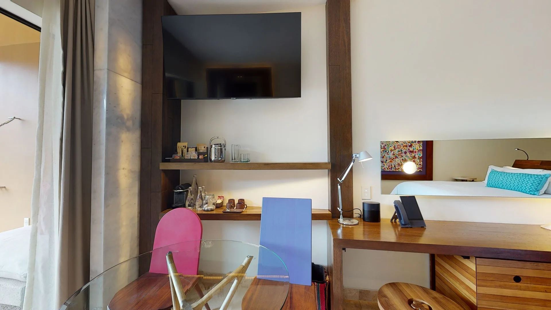 Suite river room desk, minibar shelves, TV and bed at Hotel Xcaret Arte.