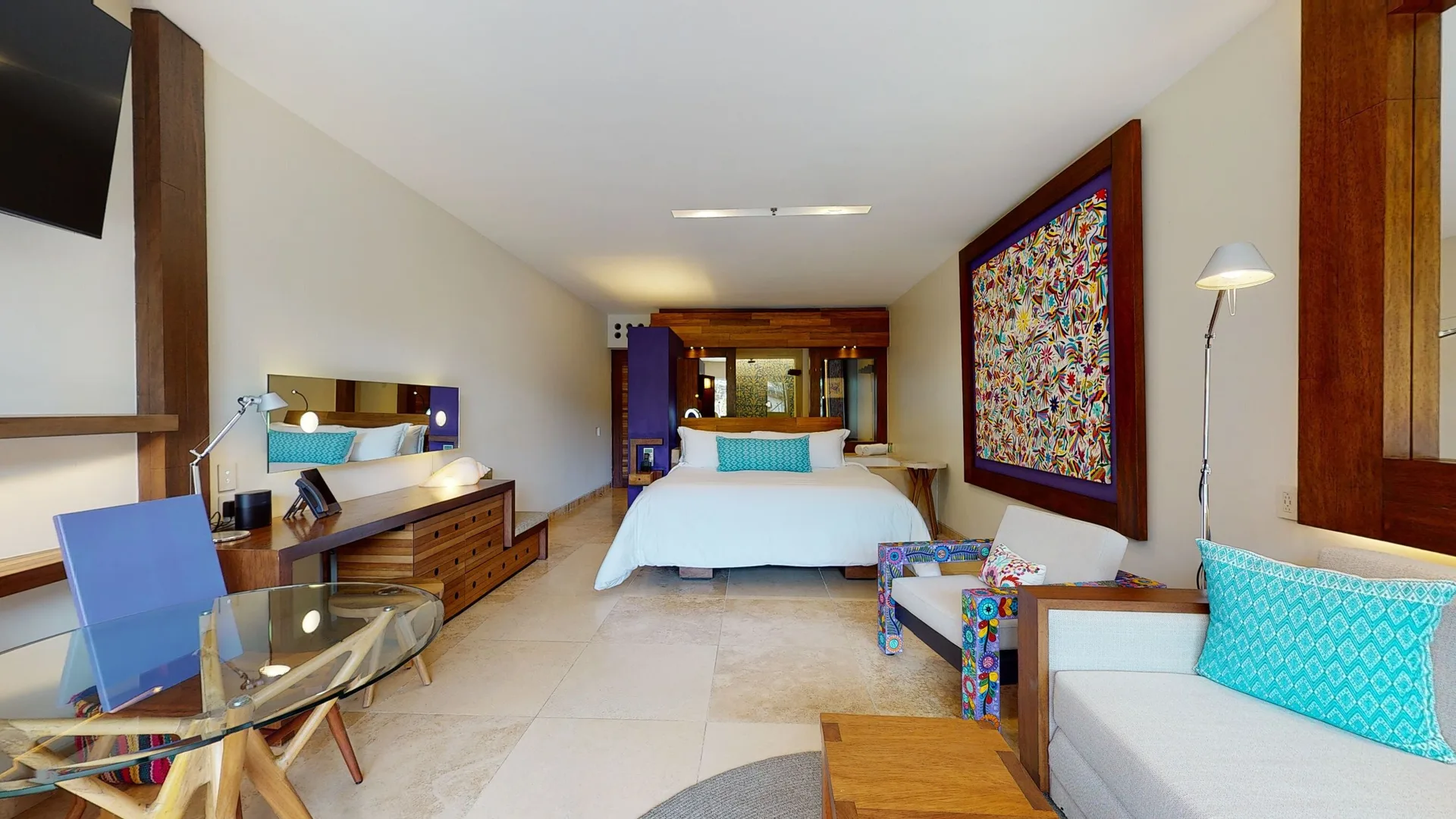 Suite river guest room with king bed, sofa and desk at Hotel Xcaret Arte.