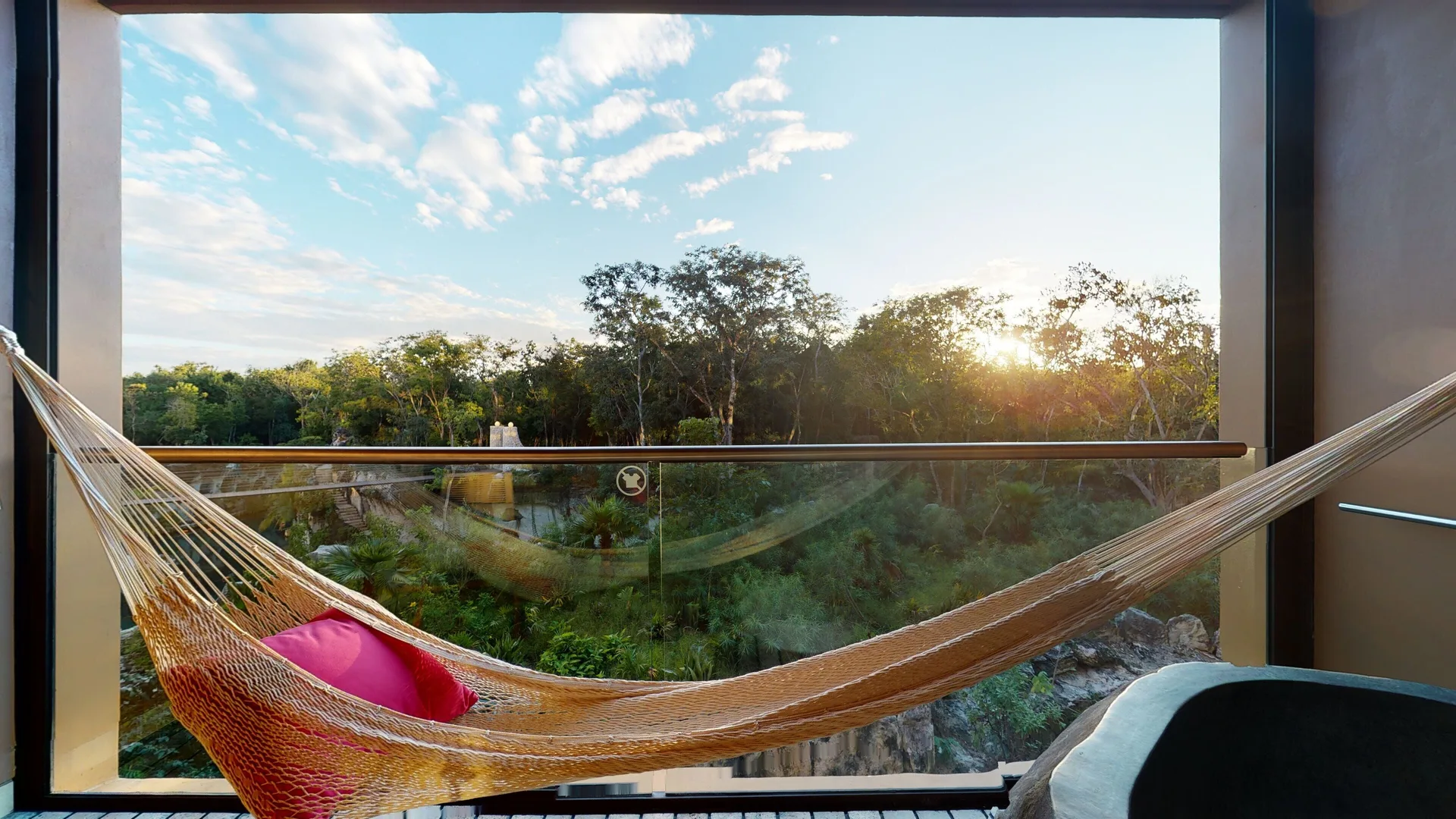 Suite River Spa balcony hammock overlooking trees at sunset at Hotel Xcaret Arte.