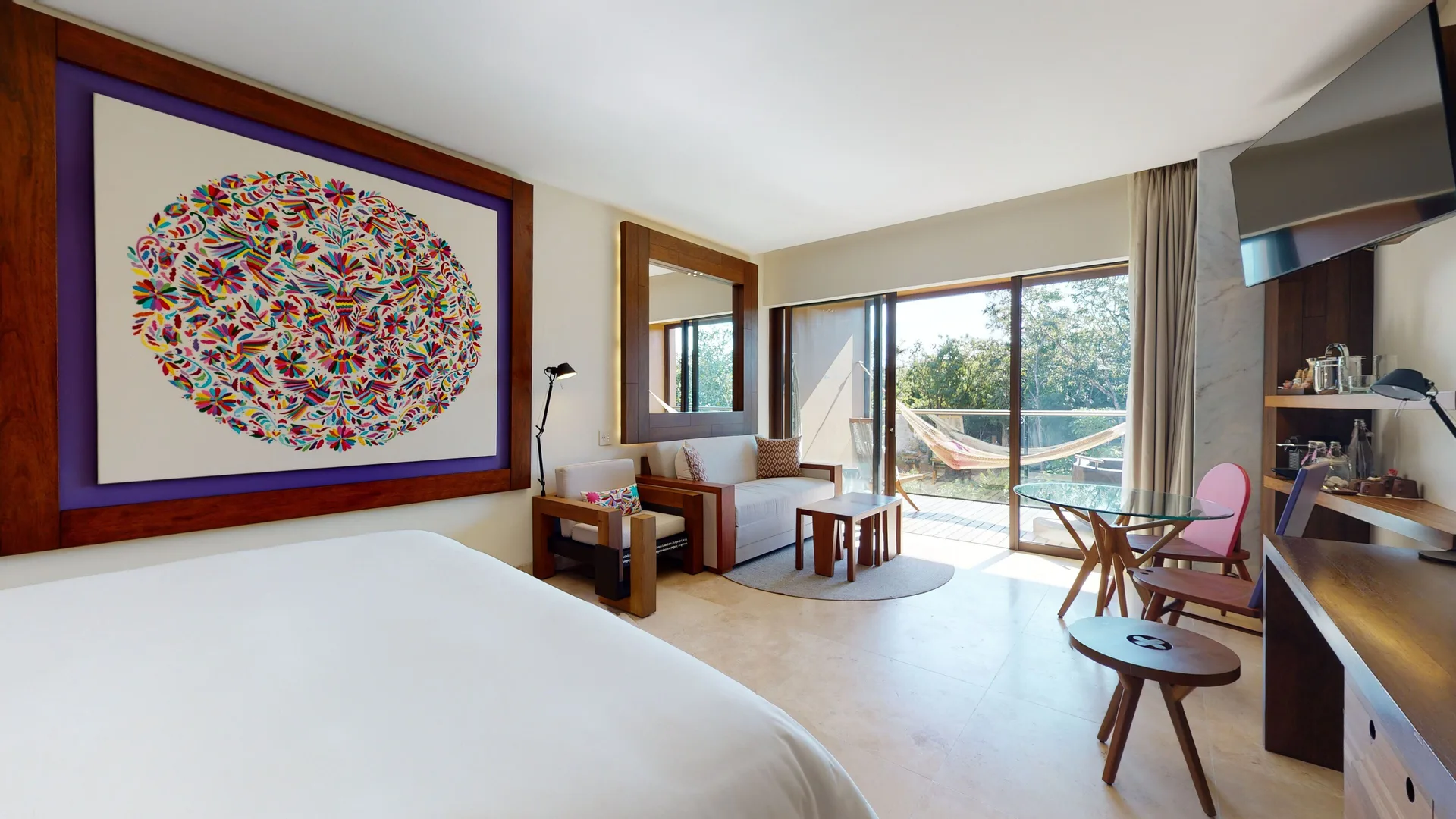 Suite River Spa king bed and sitting area opening to a balcony at Hotel Xcaret Arte.