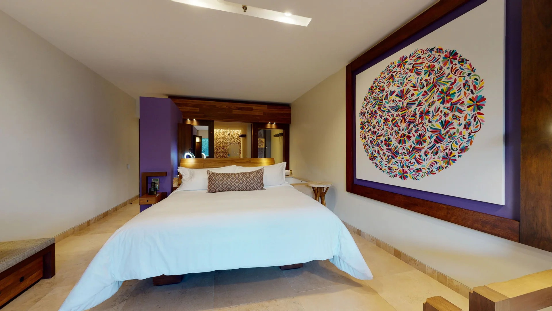 Suite River Spa king bed with colorful wall art at Hotel Xcaret Arte.