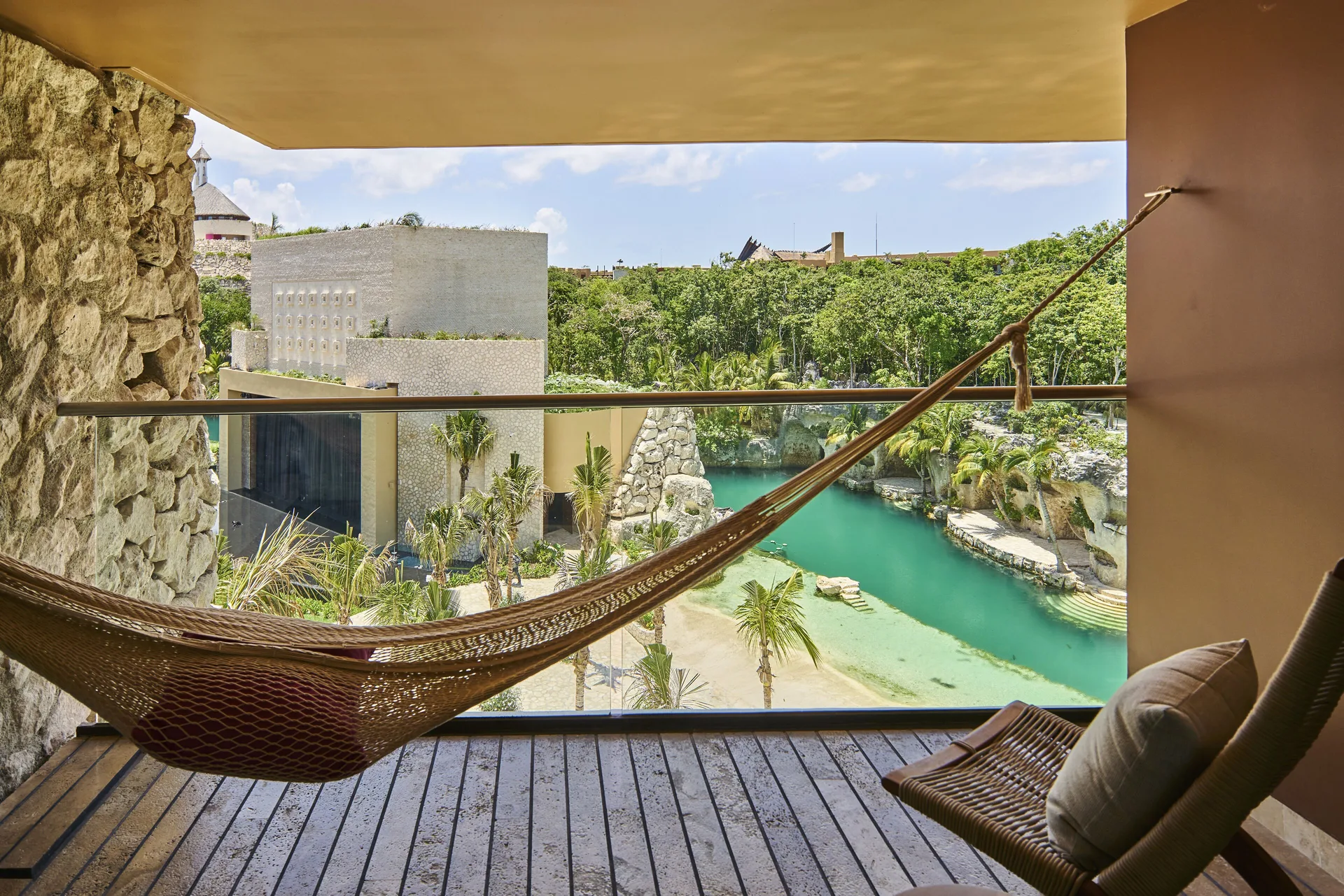 River suite balcony hammock overlooking turquoise water at Hotel Xcaret Arte.