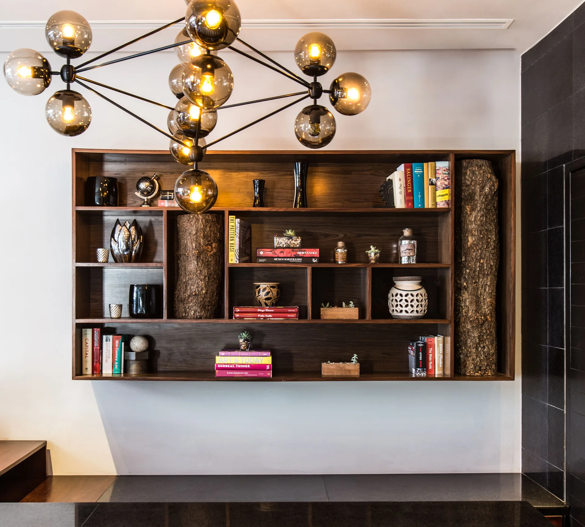 Lobby shelving with books, decor, and globe chandelier at Hyatt Centric Playa del Carmen - Downtown House & Beach House.