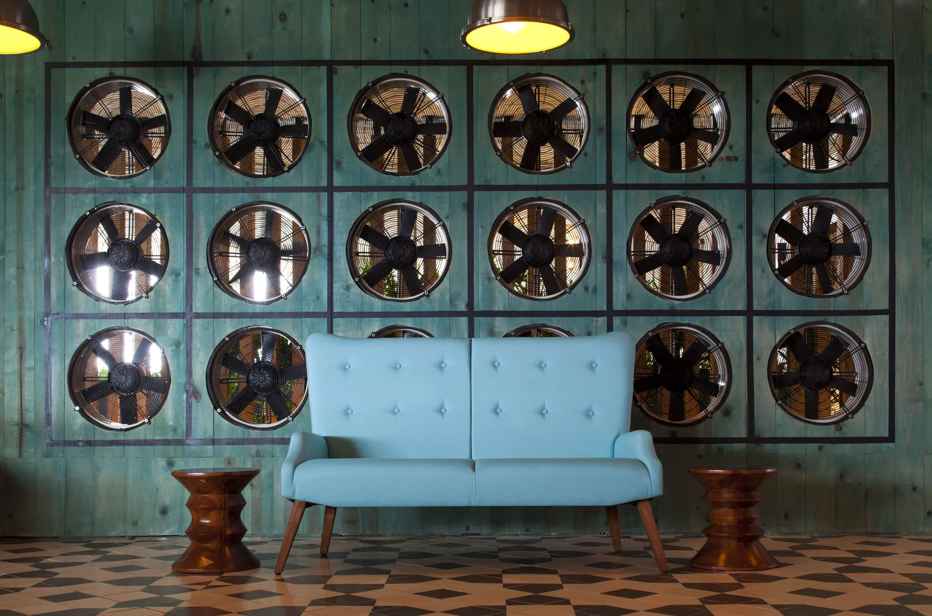 Lobby sofa before a wall of decorative fans at Hyatt Centric Playa del Carmen - Downtown House & Beach House.