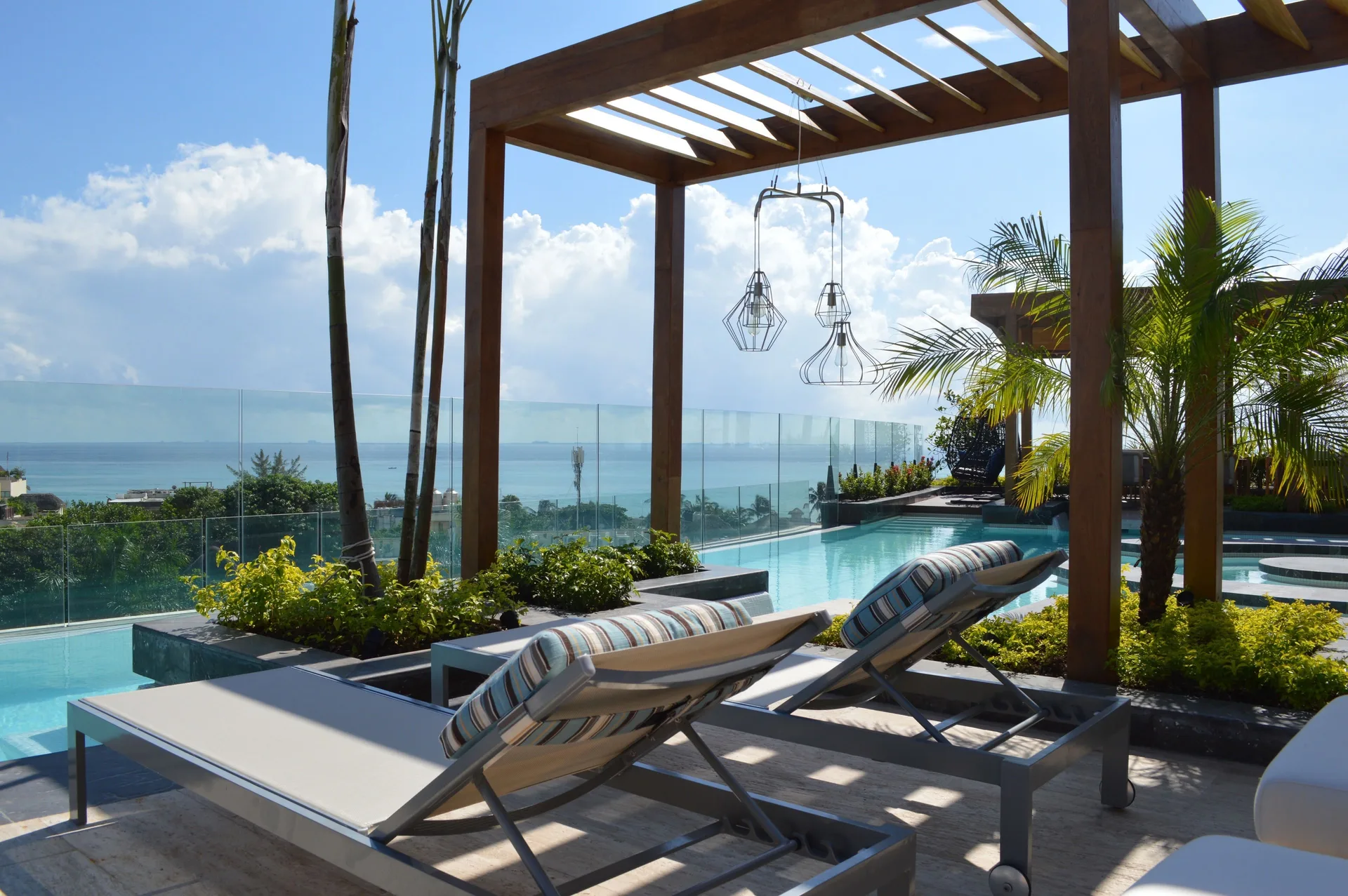 Rooftop pool loungers with ocean view at Hyatt Centric Playa del Carmen - Downtown House & Beach House.